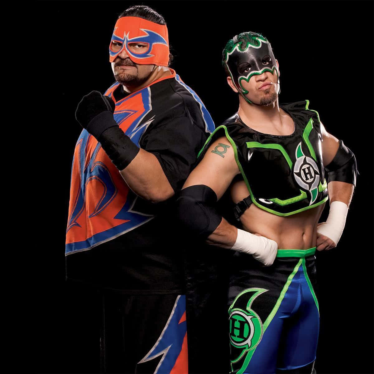 WWE 桌布 壁紙 — 兩名戴面具的摔角手，身穿鮮豔的橙色、藍色和綠色黑色裝備，在黑色背景前自信地擺姿勢。