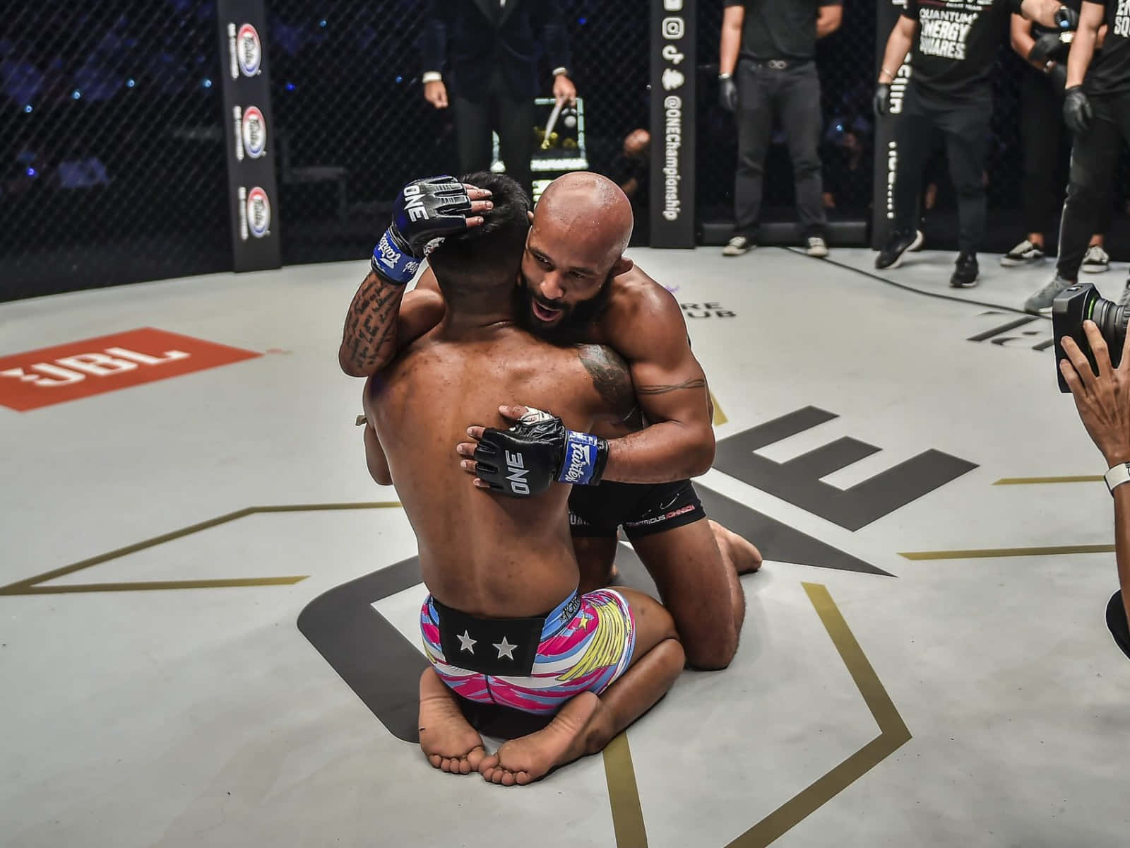 運動 桌布 壁紙 — 兩名拳手在ONE Championship八角籠墊上賽後情感擁抱。