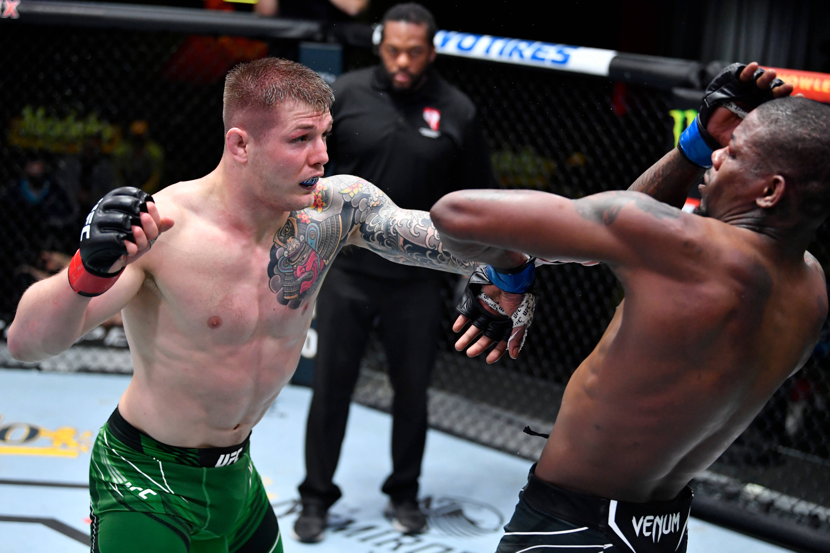 MMA 桌布 壁紙 — 兩名拳手在UFC八角籠中交鋒，一人打出強力一拳，另一人則在阻擋。