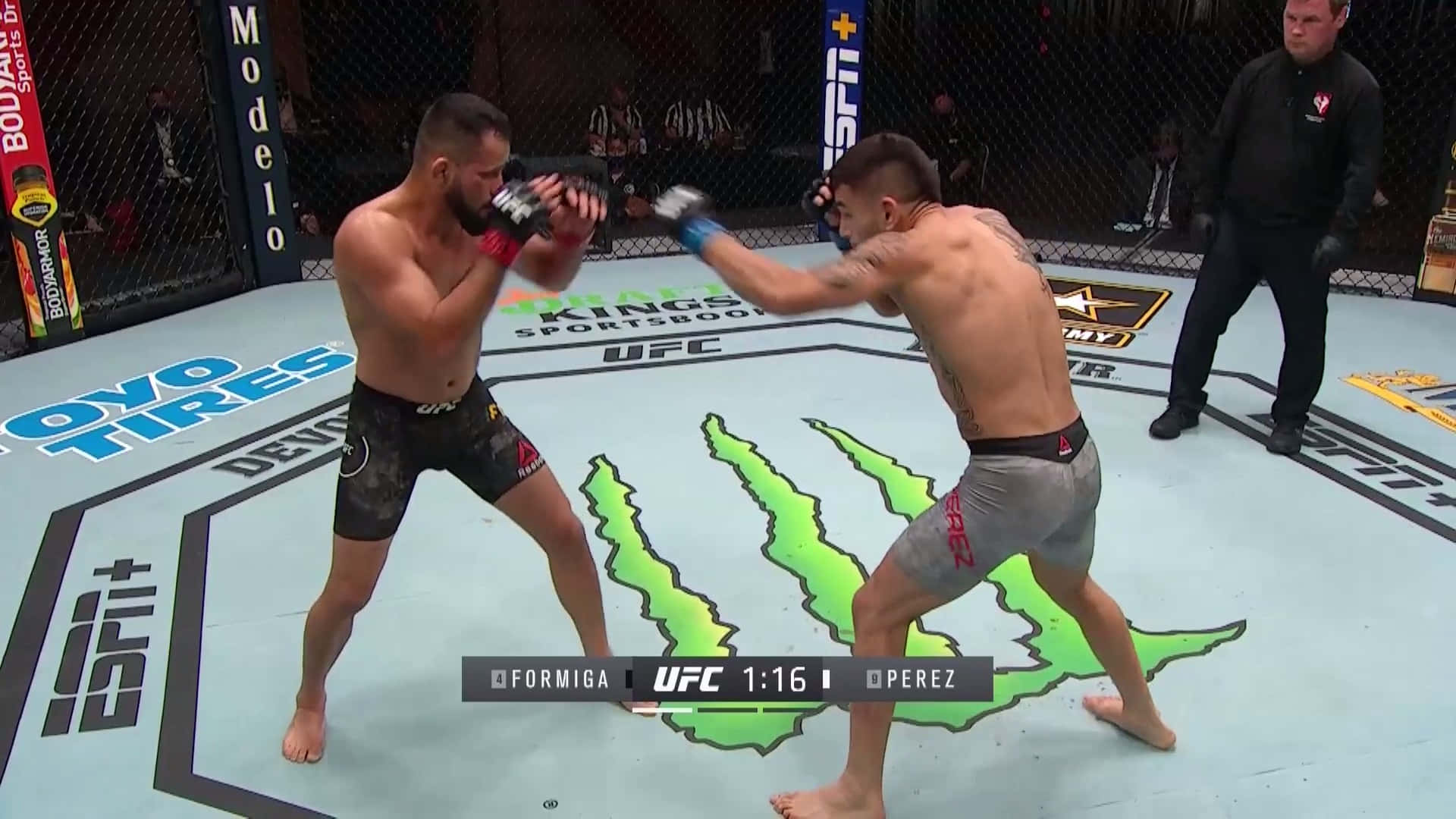 MMA 桌布 壁紙 — 兩名拳手在UFC八角籠中交鋒，一人出拳，另一人在明亮的場館燈光下格擋。