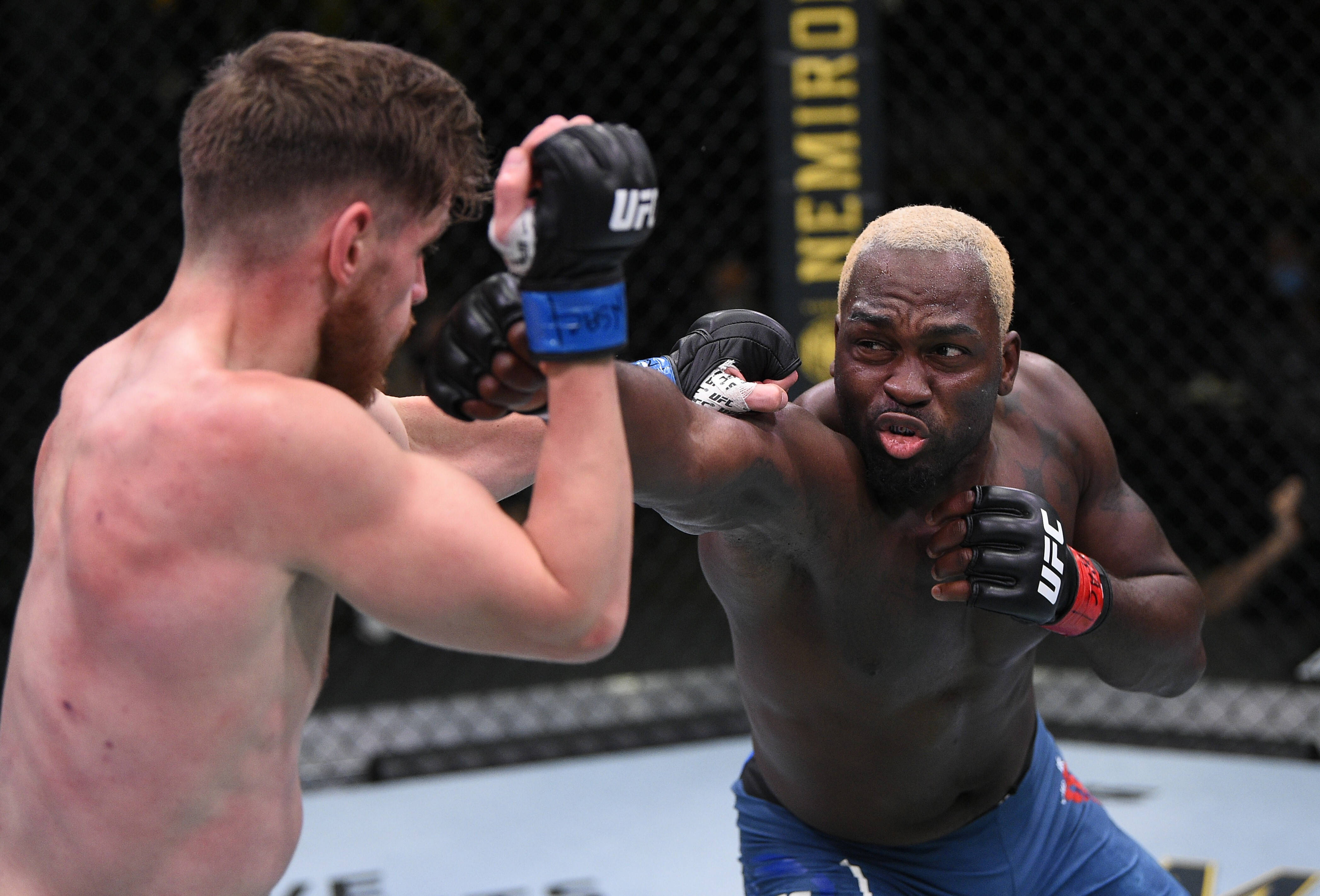 UFC 桌布 壁紙 — 兩名拳手在UFC八角籠中交鋒，其中一人向對手面部打出強力一拳。