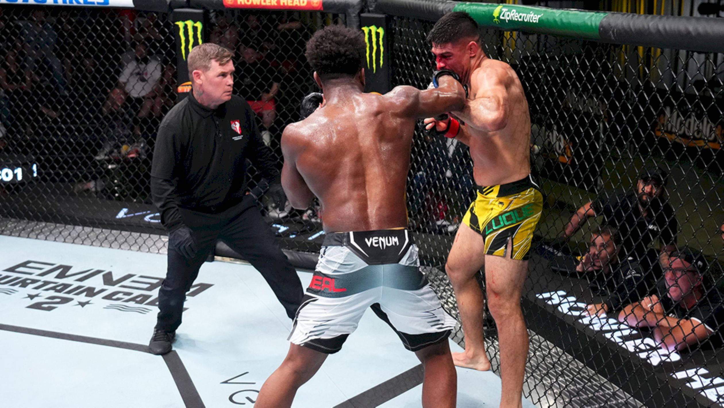 UFC 桌布 壁紙 — 兩名拳手在UFC八角籠中交鋒，裁判在高風險的綜合格鬥比賽中專注地觀看。