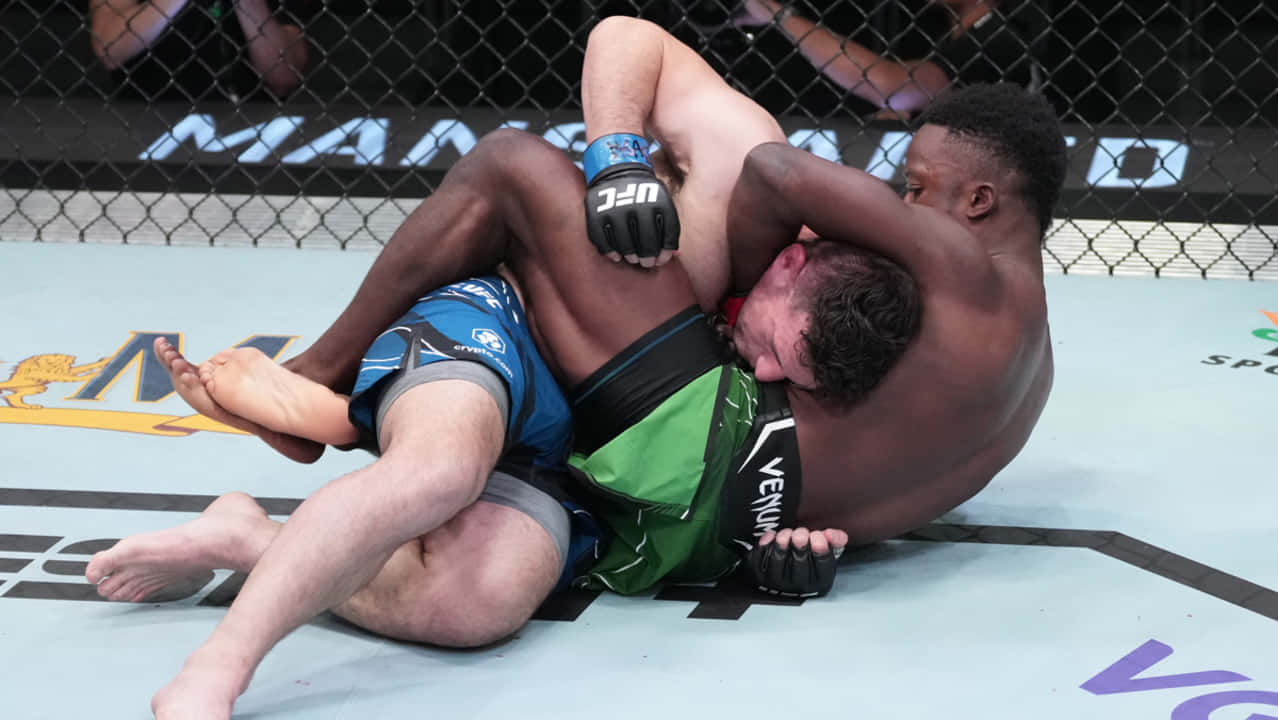UFC 桌布 壁紙 — 兩名拳手在UFC八角籠墊上激烈纏鬥，一人施展鎖喉，另一人防守。