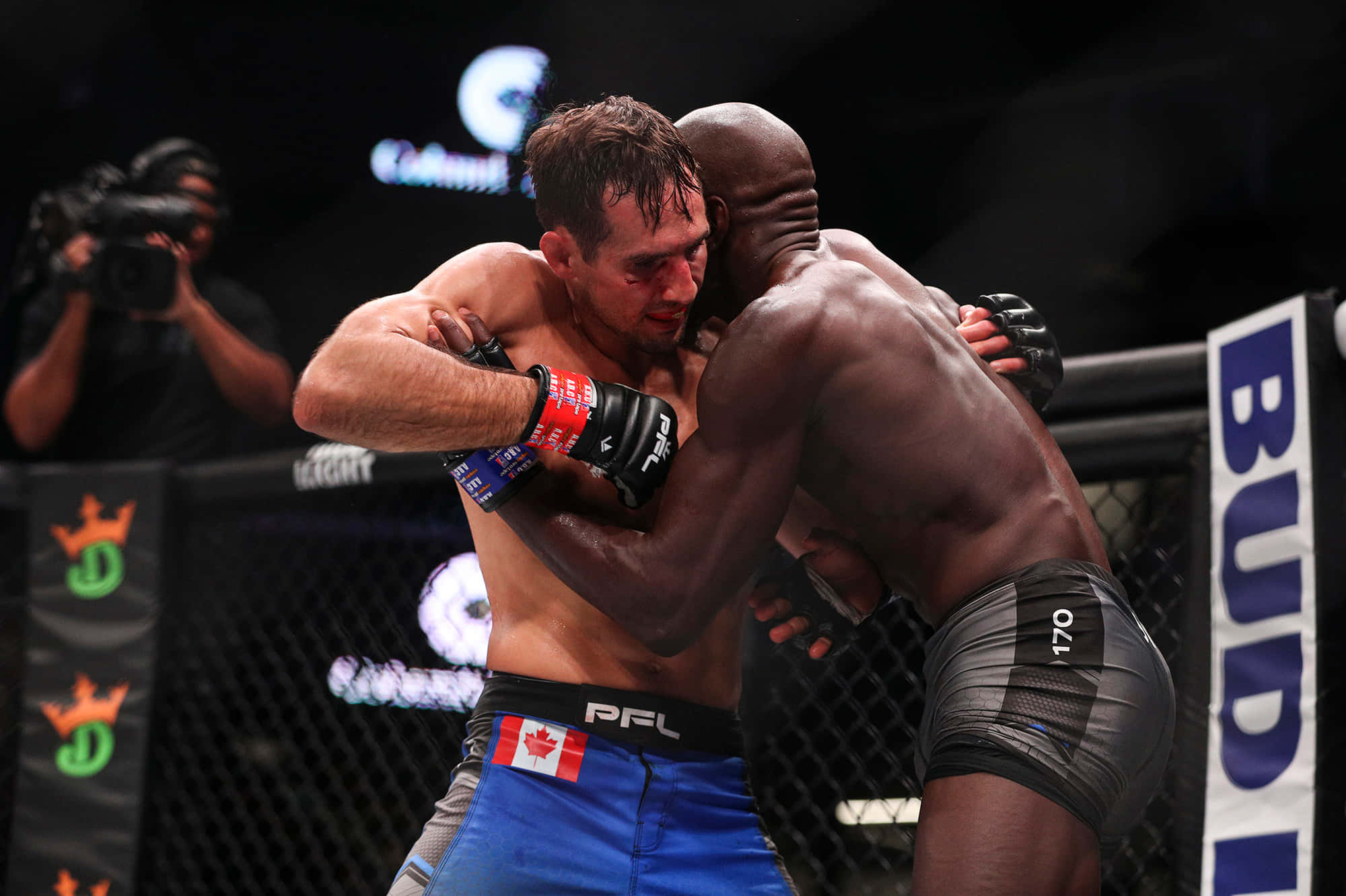 MMA 桌布 壁紙 — 兩名拳手在明亮的場館燈光下，於籠內進行激烈的職業MMA比賽，互相纏鬥。