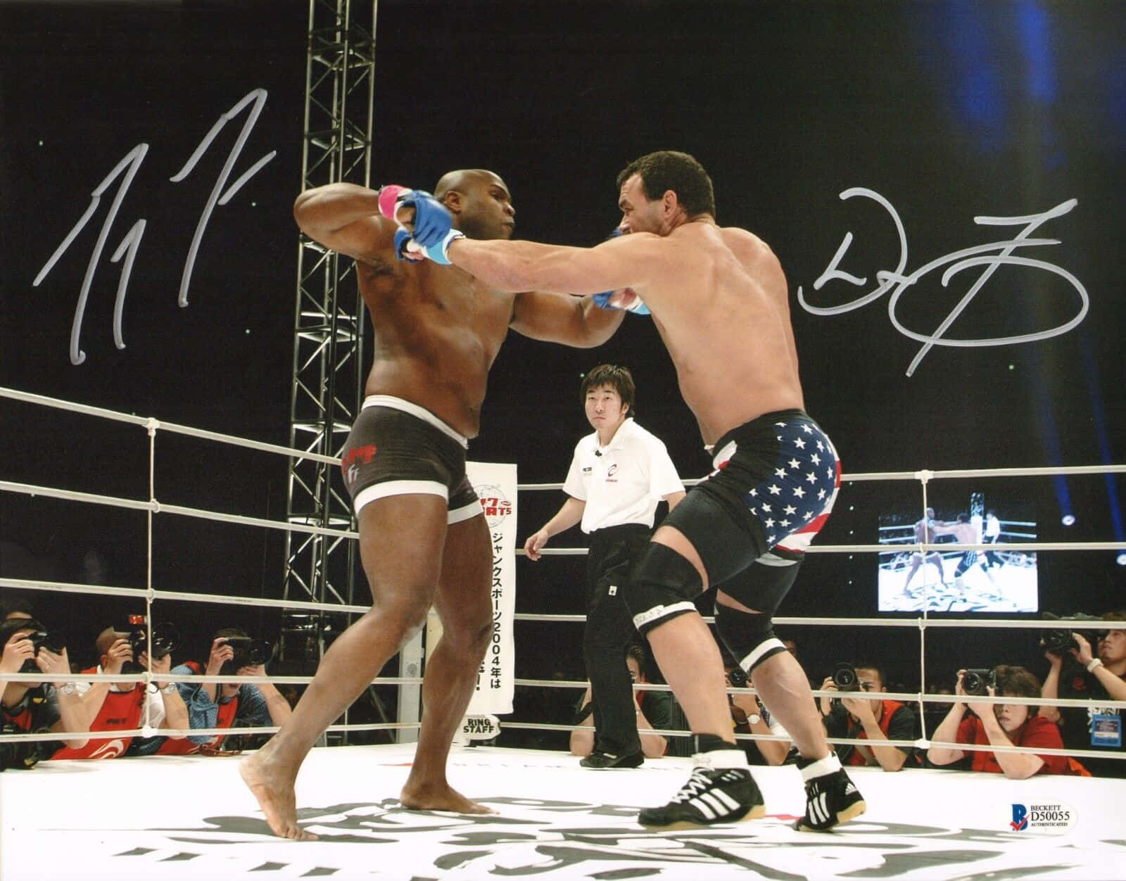 martial arts 桌布 壁紙 — 兩名拳手在燈光明亮的MMA擂台上交鋒，裁判注視著，攝影師捕捉這緊張時刻。