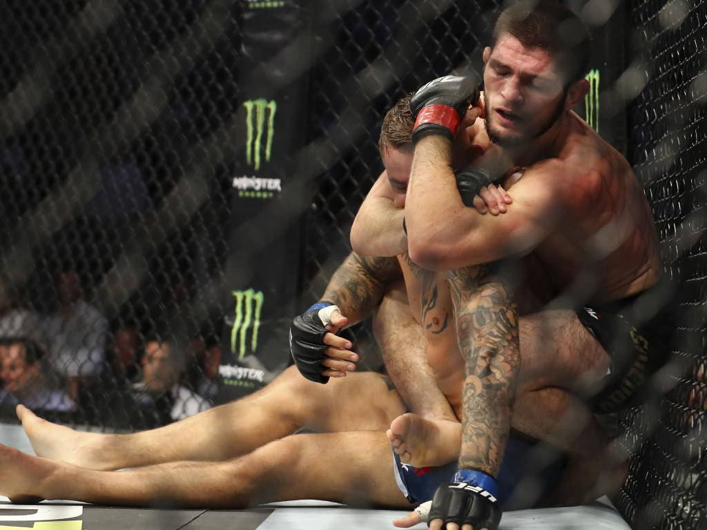 UFC 桌布 壁紙 — 兩名拳手在籠中激烈纏鬥，進行混合武術比賽，可見血跡和紋身。