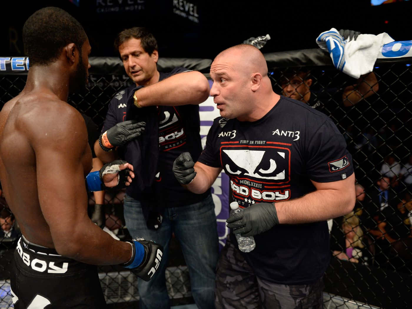 UFC 桌布 壁紙 — 兩名拳手在籠內對峙，裁判在明亮的場館燈光下介入一場混合武術比賽。