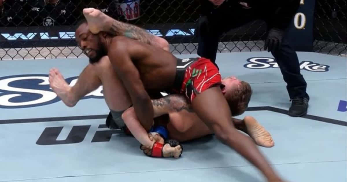 UFC 桌布 壁紙 — 兩名拳手在藍色八角形擂台上激烈纏鬥，裁判在旁緊密注視。