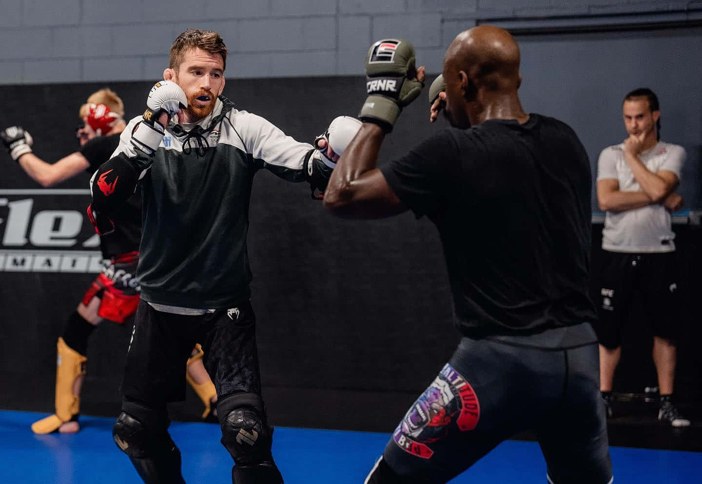 Punch 桌布 壁紙 — 兩名拳手在骯髒的室內MMA訓練館中激烈碰撞，汗水飛濺，專注度極高。