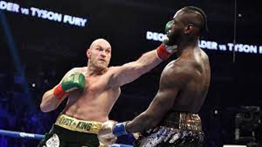 Tyson Fury 桌布 壁紙 — 兩名拳擊手在戲劇性的擂台上交鋒，其中一人在明亮的場館燈光下揮出強力一拳。