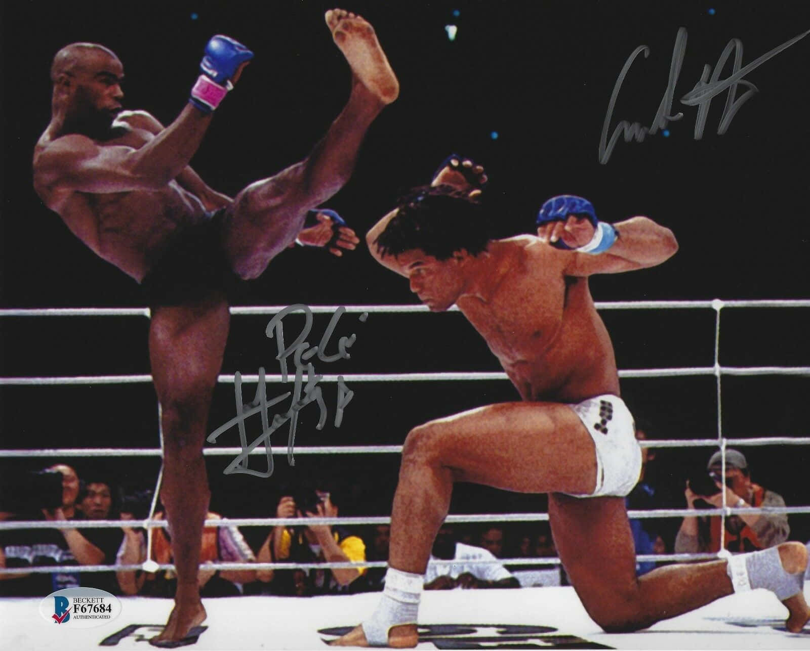 MMA 桌布 壁紙 — 兩名拳擊手在拳擊場上交鋒，一人使出高踢，另一人以蹲姿防守。