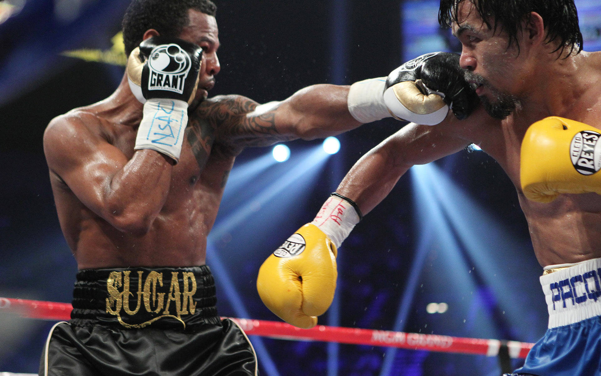 黑色 桌布 壁紙 — 兩名拳擊手在明亮的聚光燈下進行激烈的擂台比賽，汗水在拳擊中飛濺。