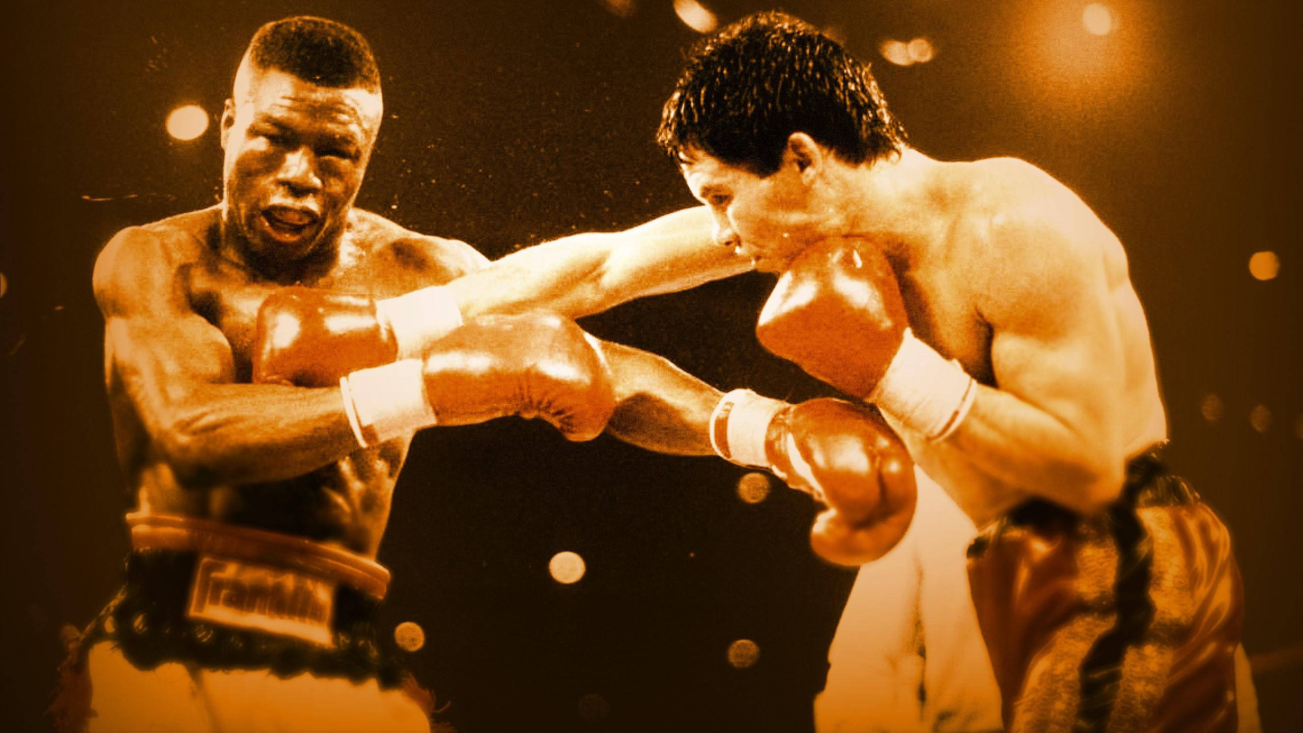 Boxing 桌布 壁紙 — 兩名拳擊手在溫暖的聚光燈下進行一場戲劇性的擂台比賽，汗水飛濺，表情激烈。