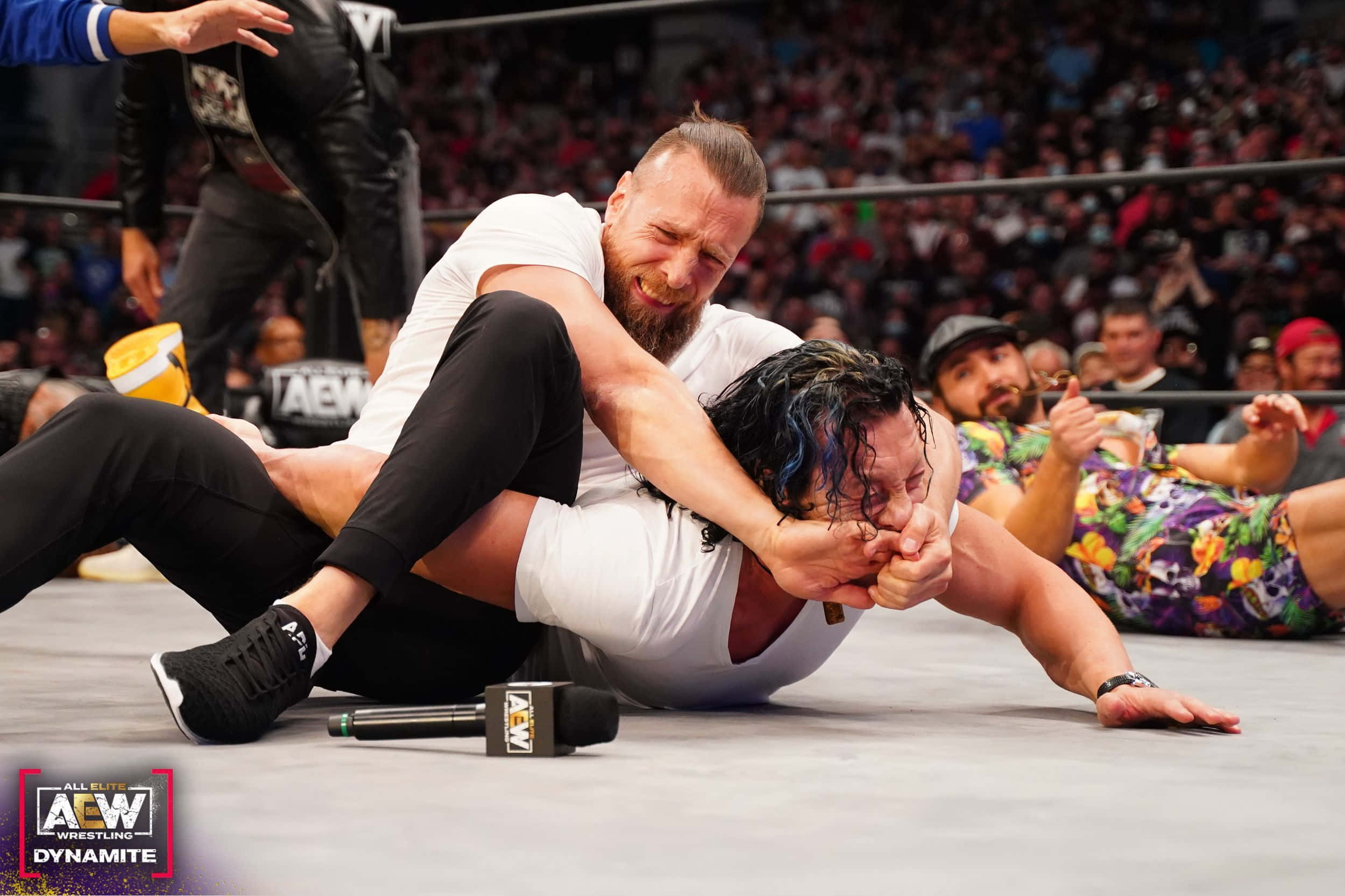 cm punk 桌布 壁紙 — 兩名摔角手在擂台上激烈纏鬥，觀眾從看台上觀看。