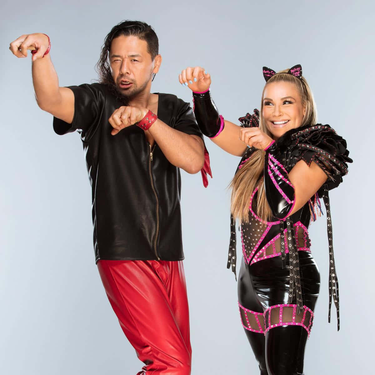 WWE 桌布 壁紙 — 兩名摔角手在純灰色工作室背景前，穿著大膽的黑紅服裝擺出動態姿勢。