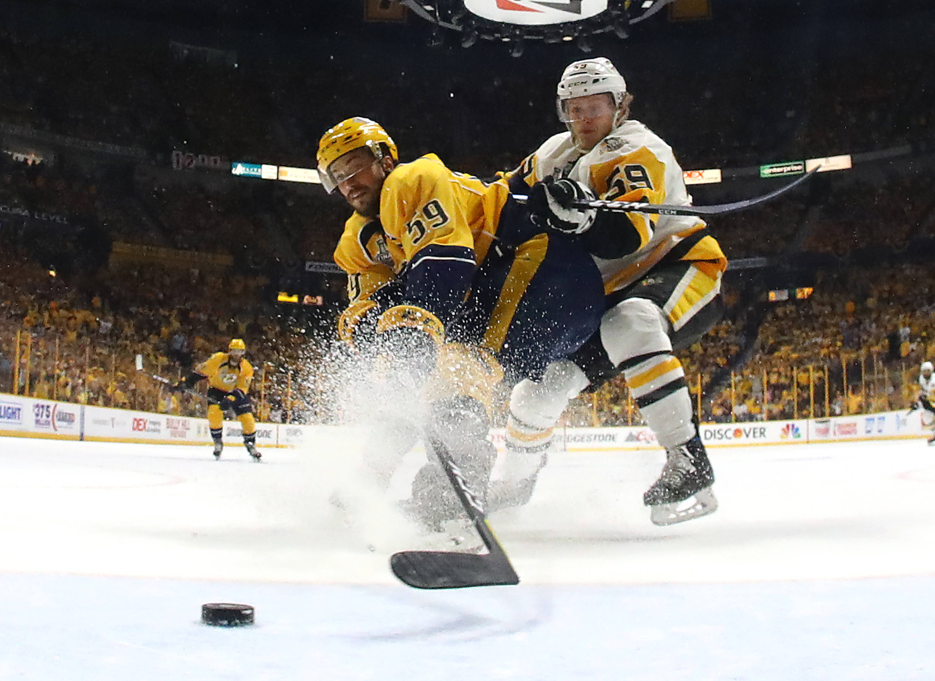 hockey 桌布 壁紙 — 兩名曲棍球運動員在冰上激烈碰撞，在擠滿觀眾的場館比賽中激起一片雪花。