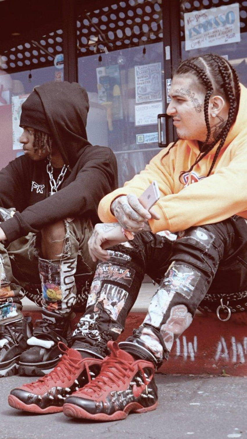 Zillakami 桌布 壁紙 — 兩名有刺青和辮子的年輕男子坐在塗鴉覆蓋的壁架上，穿著街頭服飾和紅色運動鞋。