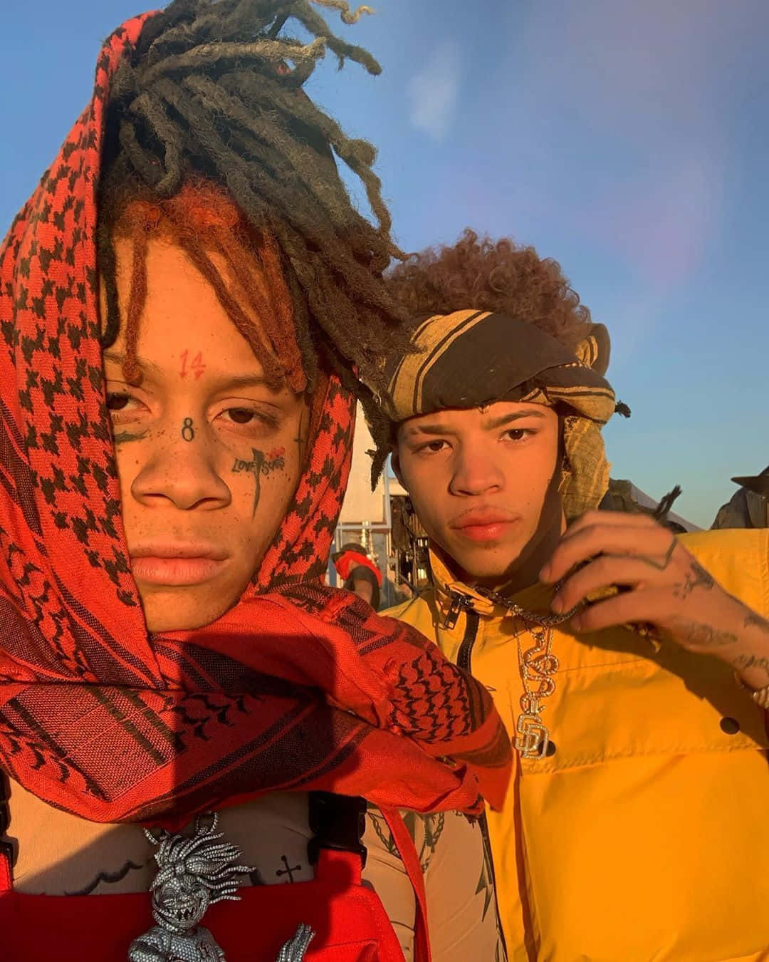 Lil Mosey 桌布 壁紙 — 兩名有刺青和造型頭髮的年輕男子在黃金時段對著晴朗的藍天擺姿勢。