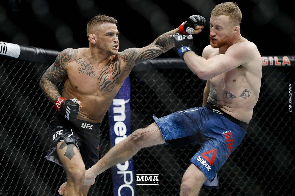MMA 桌布 壁紙 — 兩名有刺青的MMA拳手在激烈的鐵籠賽中交鋒，其中一人使出高踢。
