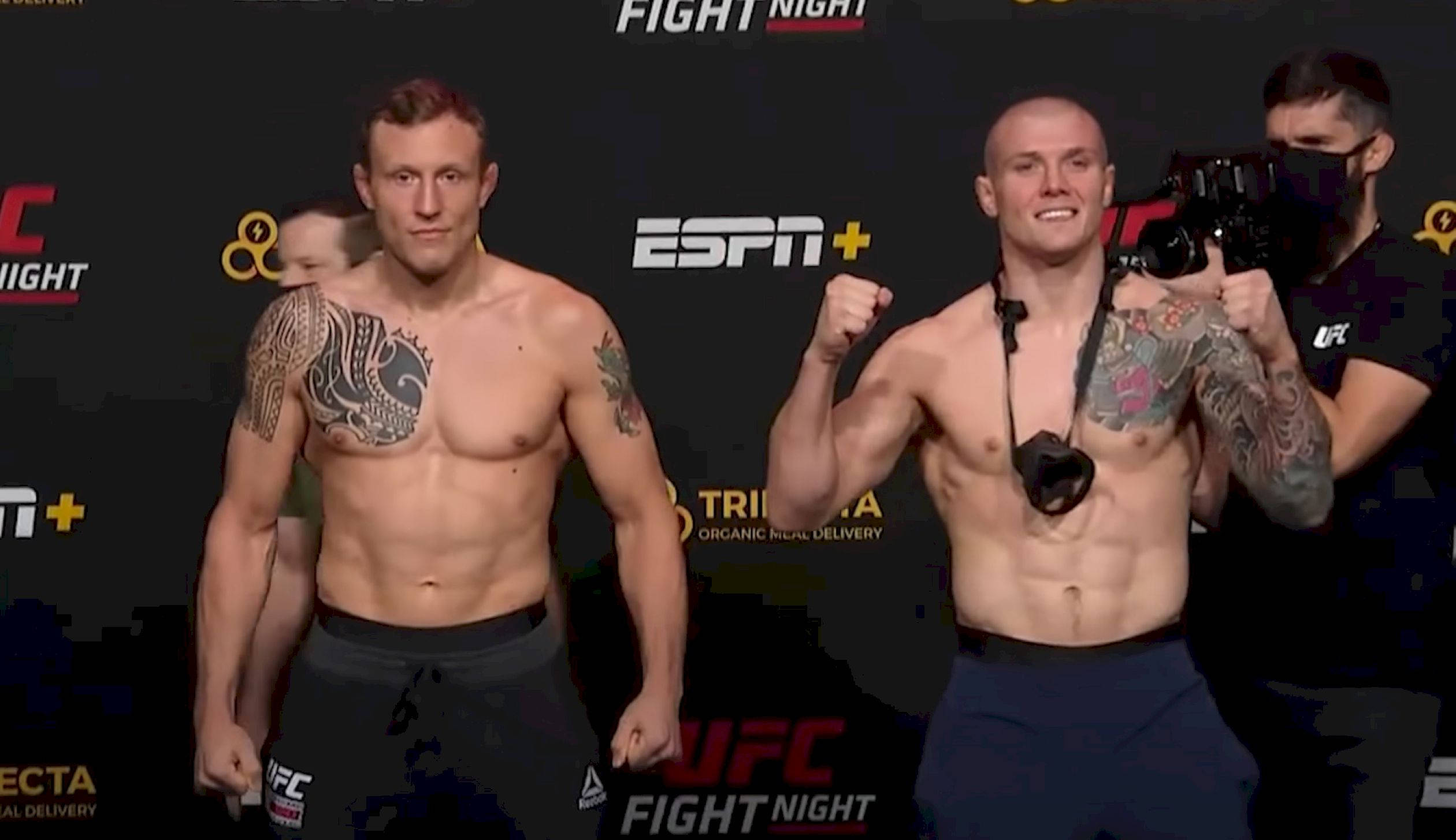 MMA 桌布 壁紙 — 兩名有刺青的UFC拳手在稱重活動中自信地擺姿勢，背後有ESPN+和UFC品牌標誌。