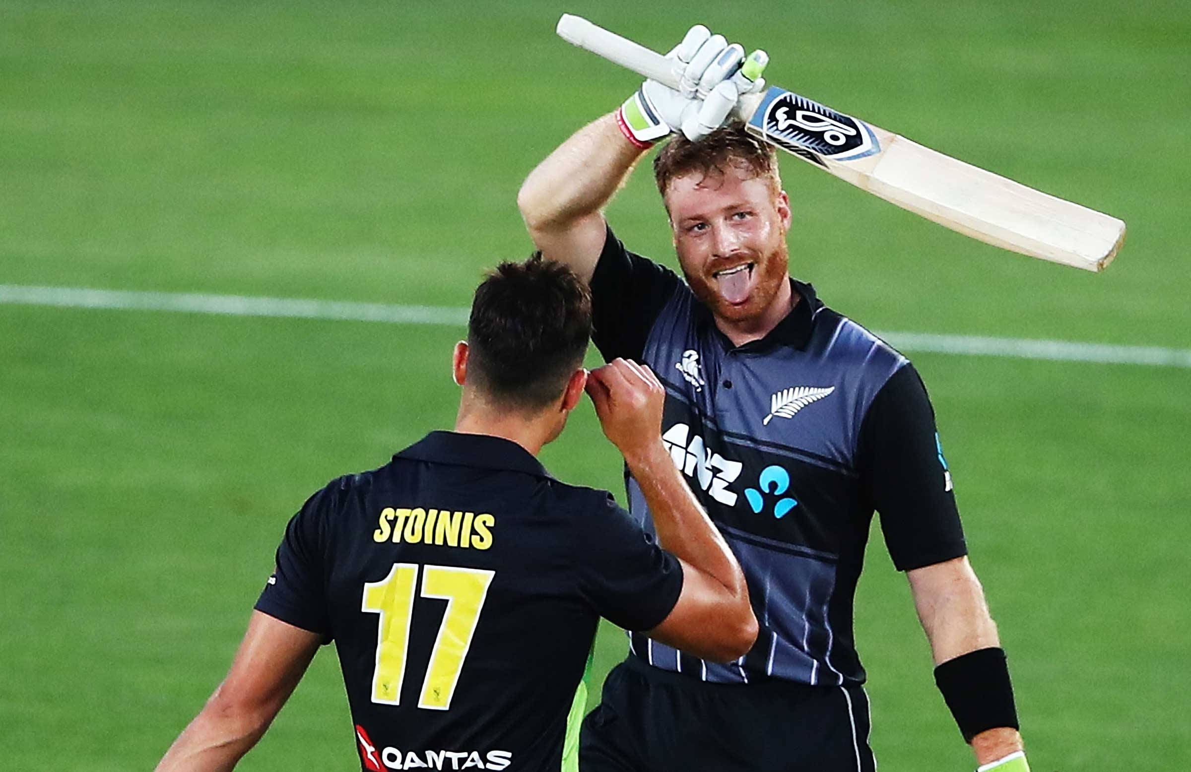 martin guptill 桌布 壁紙 — 兩名板球運動員在綠色場地上慶祝，其中一人舉起球棒並伸出舌頭。