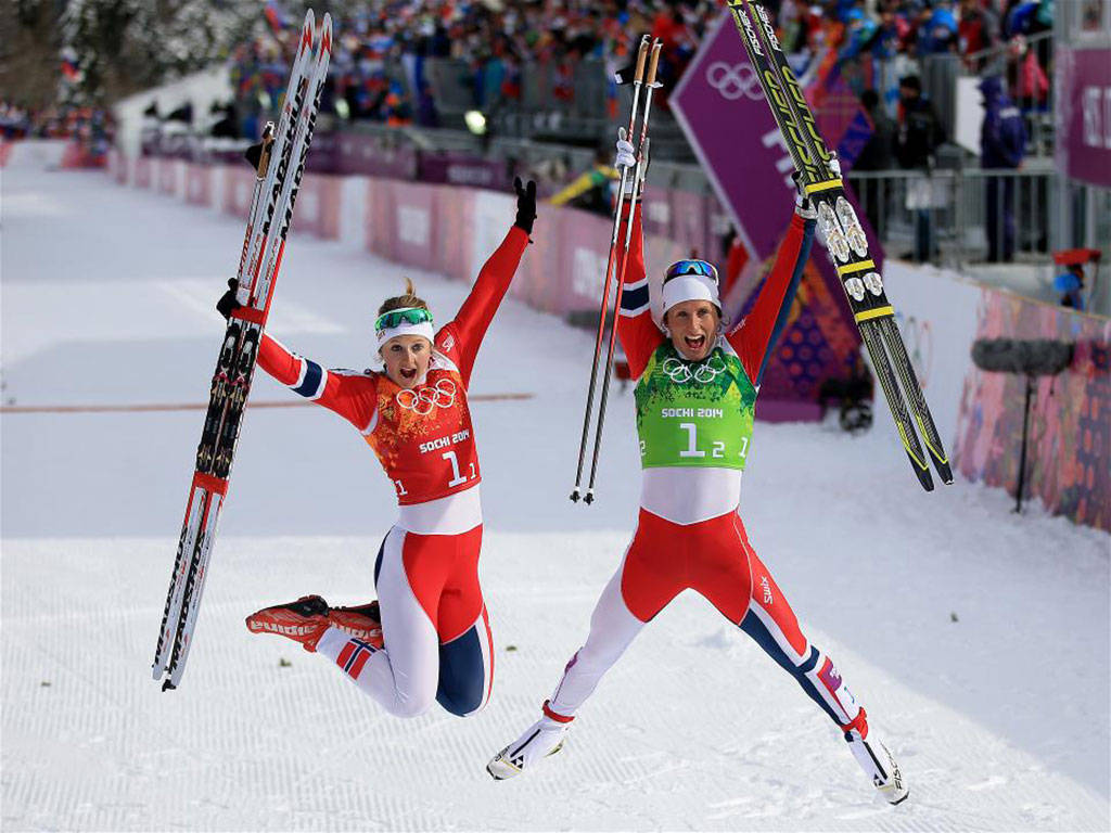 Winter Olympics 桌布 壁紙 — 兩名歡樂的女子越野滑雪運動員在2014年索契冬奧會上高舉滑雪板勝利跳躍。
