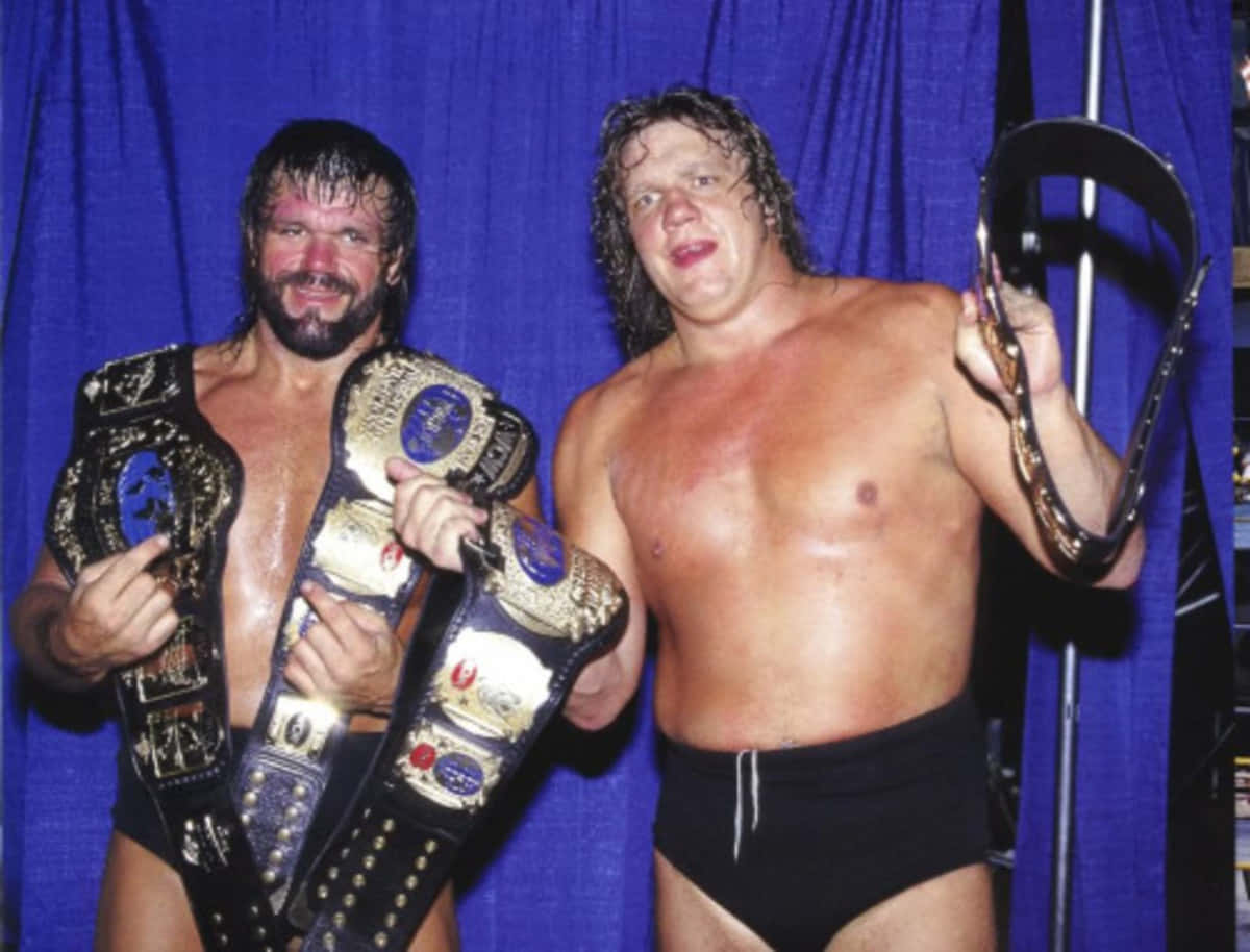 摔角 桌布 壁紙 — 兩名汗流浹背的摔角手在皇家藍色窗簾背景下自豪地咧嘴笑著，手持冠軍腰帶。