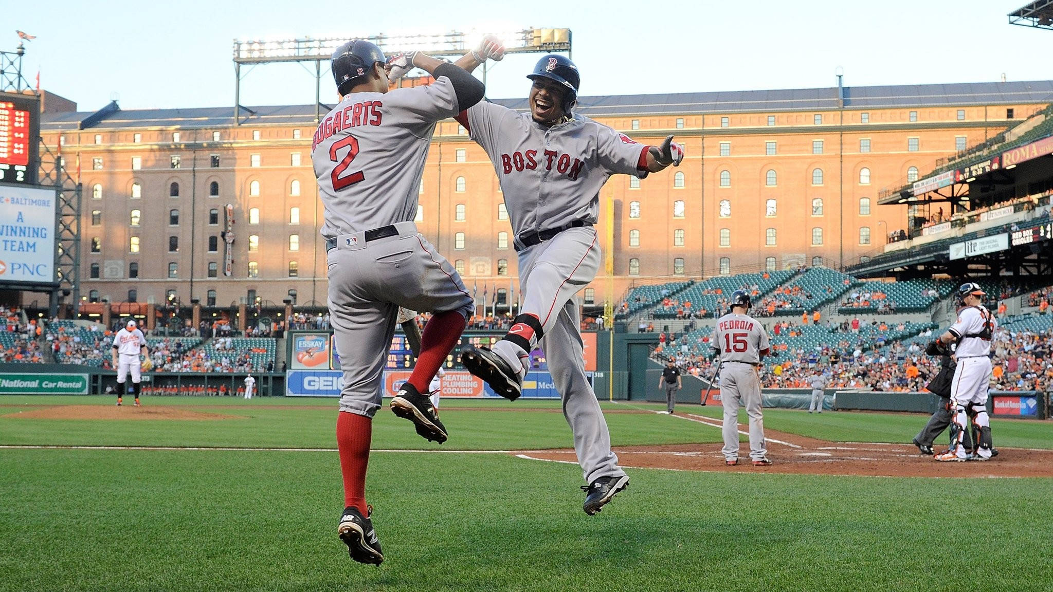 Red Sox 桌布 壁紙 — 兩名波士頓棒球選手在日間比賽中於擠滿觀眾的球場上跳起慶祝全壘打。