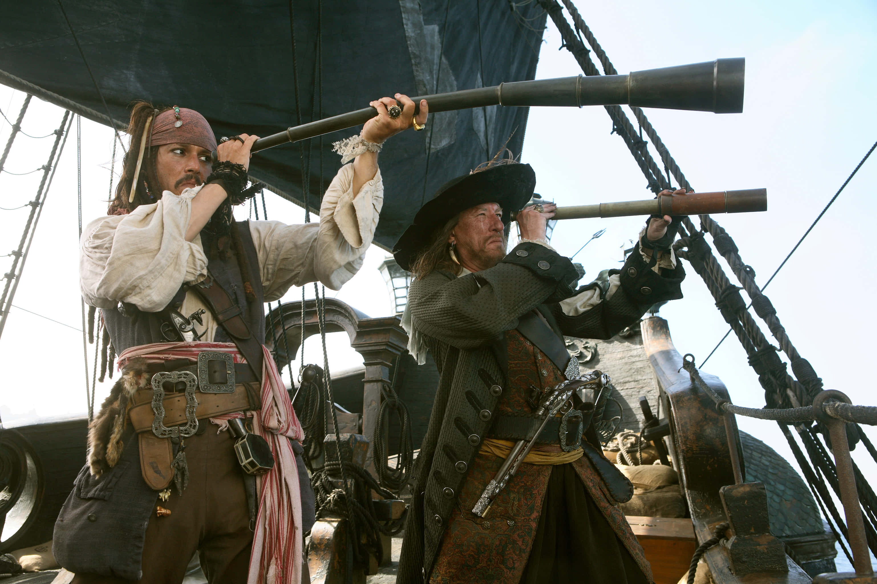 Pirates Of The Caribbean 桌布 壁紙 — 兩名海盜在船甲板上透過望遠鏡掃視地平線，天空明亮。