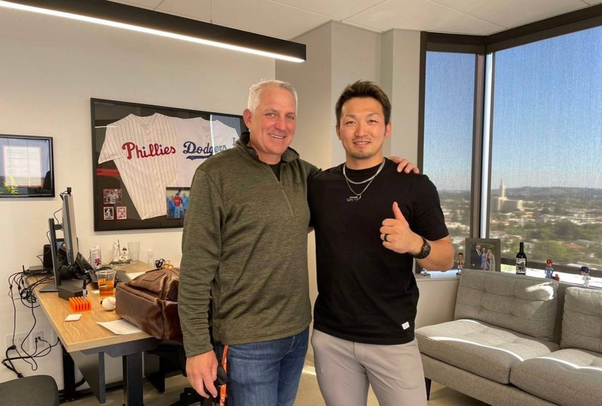 Thumbs Up 桌布 壁紙 — 兩名男子在現代辦公室微笑擺姿勢，透過大窗戶可欣賞城市景觀。