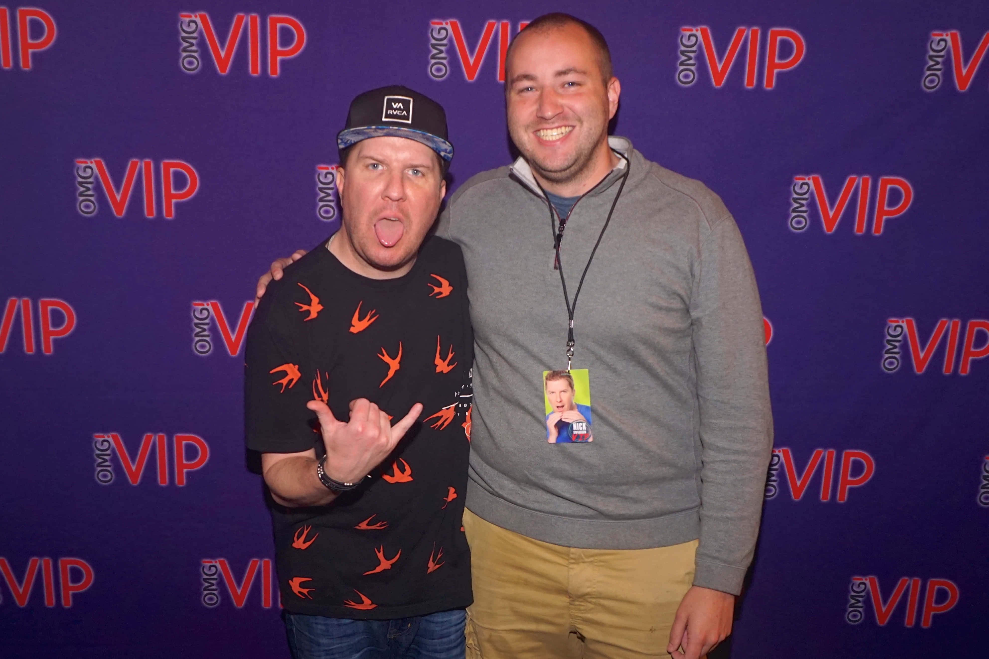 Nick Swardson 桌布 壁紙 — 兩名男子在紫色VIP背景前愉快地擺姿勢，其中一人做出俏皮的手勢。