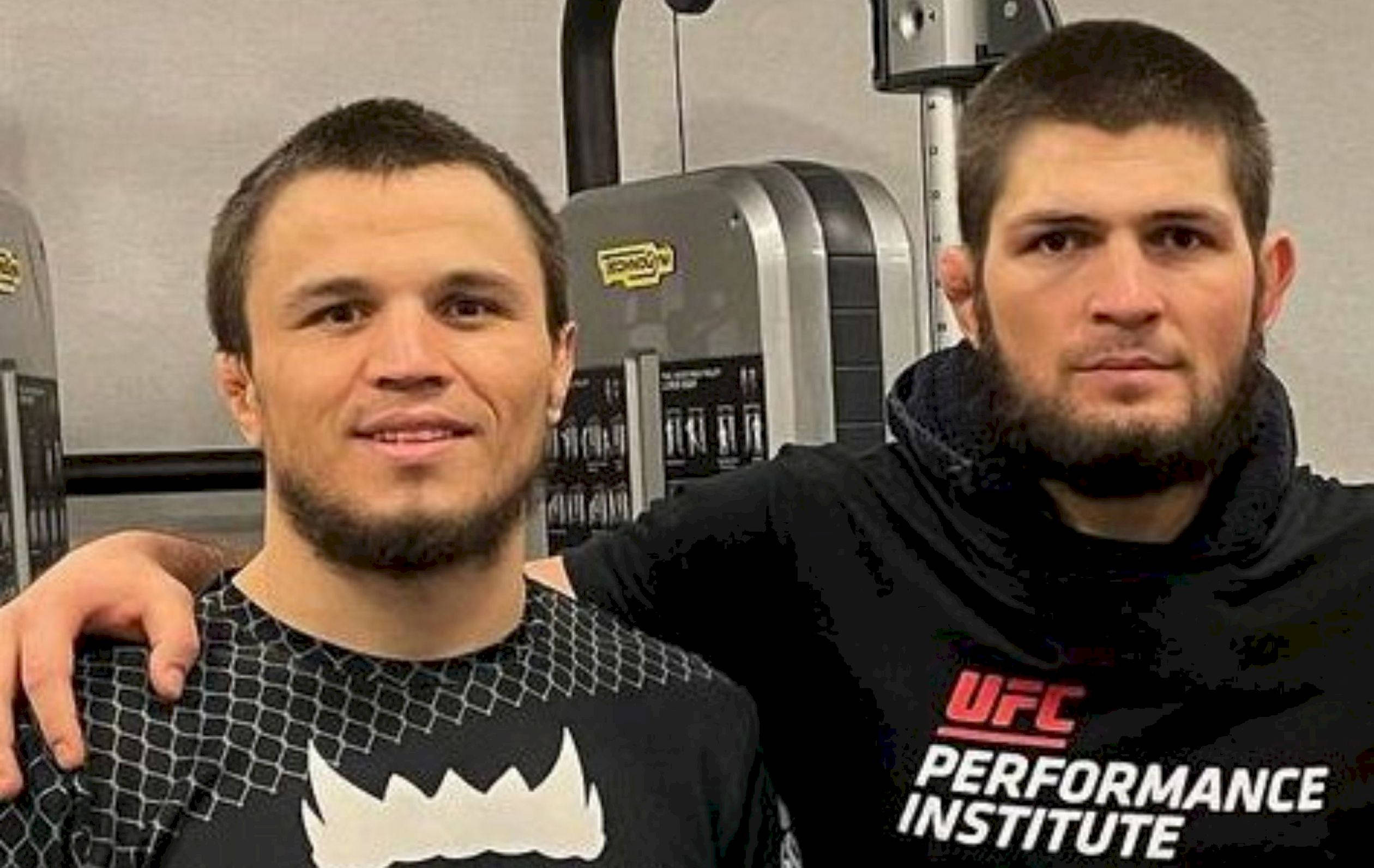 MMA 桌布 壁紙 — 兩名男性拳手在健身房內擺姿勢，身後有舉重器材，其中一人穿著UFC Performance Institute連帽上衣。