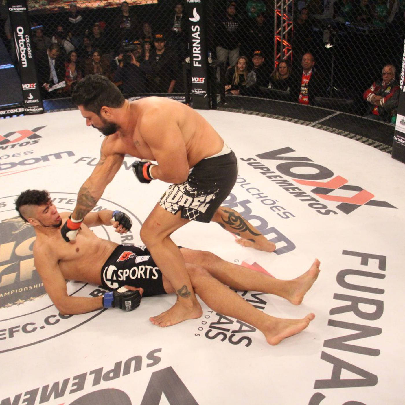 MMA 桌布 壁紙 — 兩名男性拳手在綜合格鬥籠中，一人處於上方執行地面技術，另一人防守。