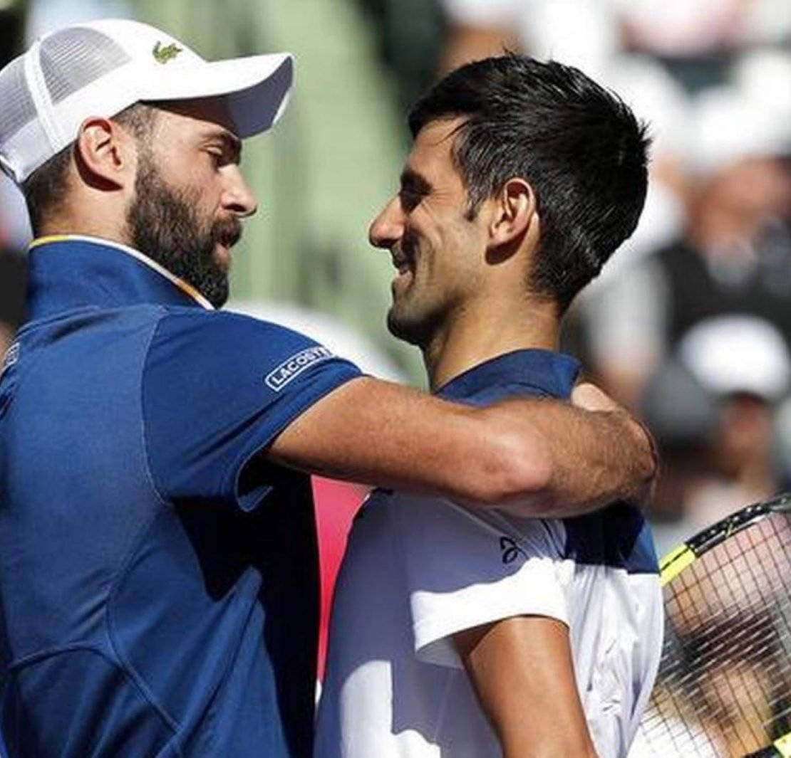 Tennis 桌布 壁紙 — 兩名男性網球運動員在陽光明媚的球場上熱情擁抱，背景觀眾模糊。