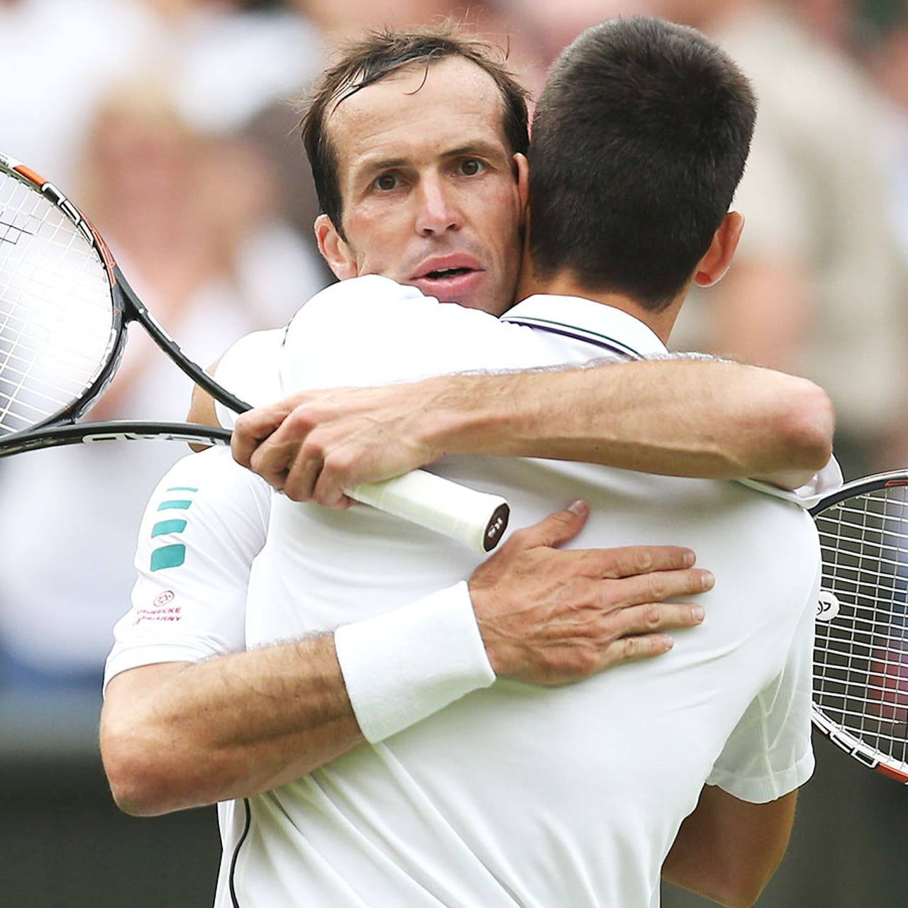 Tennis 桌布 壁紙 — 兩名男性網球選手在草地上熱情擁抱，手持球拍。