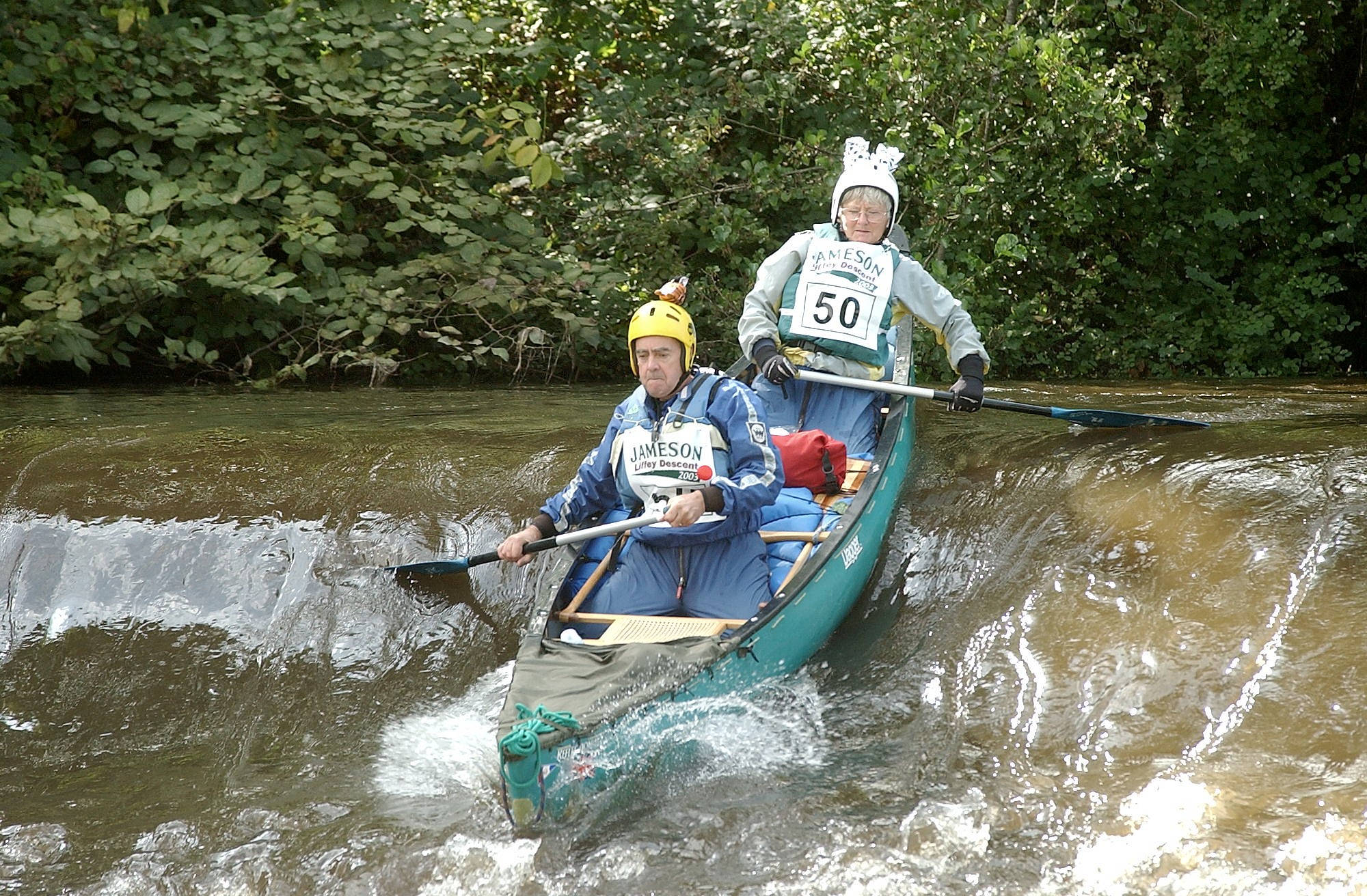 Rowing 桌布 壁紙 — 兩名皮划艇運動員在青綠色獨木舟上，穿越被茂密綠色森林包圍的湍急白水急流。