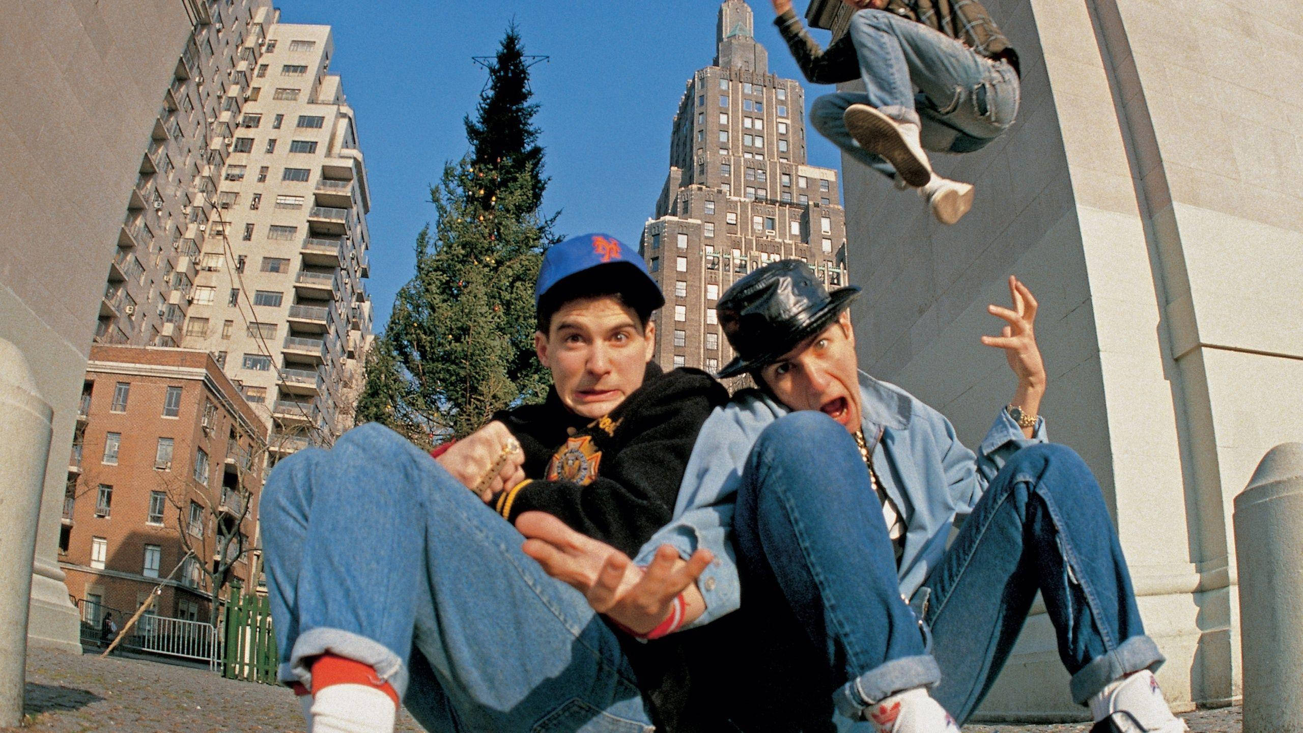 Rappers 桌布 壁紙 — 兩名穿著90年代街頭服的年輕男子在摩天大樓和一棵孤樹的城市背景下，在明亮的藍天下充滿活力地擺姿勢。