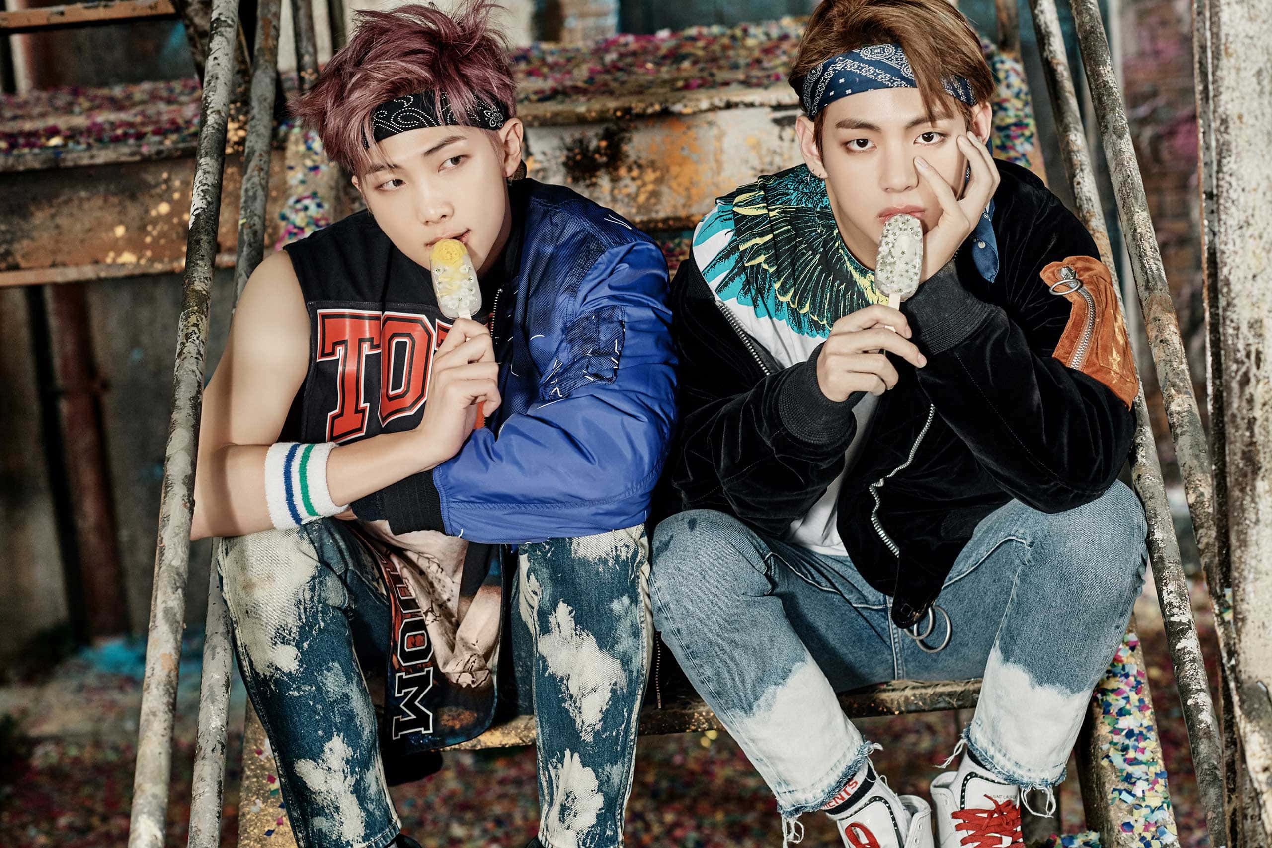 Bts Rap Monster 桌布 壁紙 — 兩名穿著時尚街頭服的年輕男子坐在生鏽的梯子上，在粗糙的城市環境中吃冰淇淋。