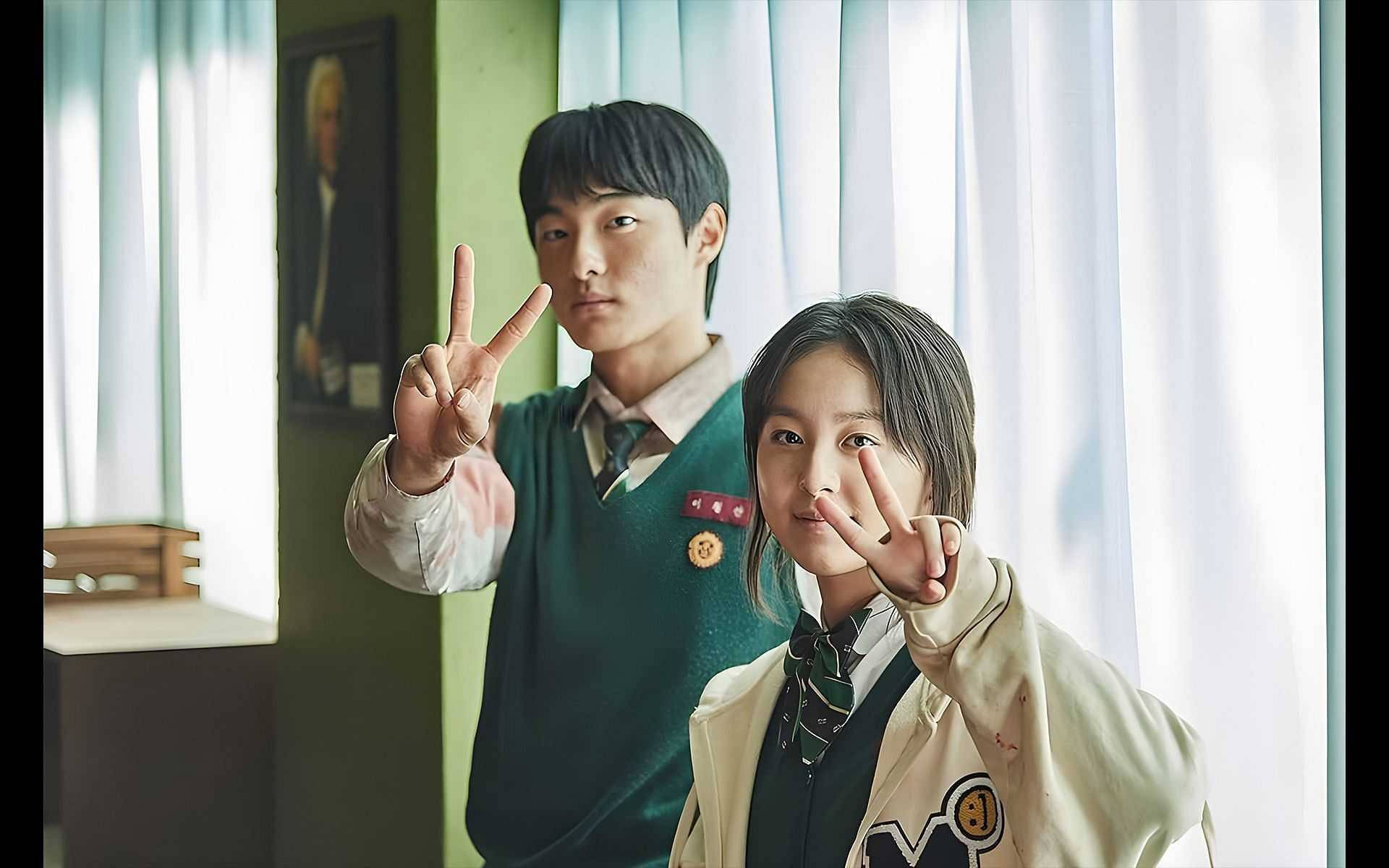 kdrama 桌布 壁紙 — 兩名穿著校服的學生在窗簾附近的陽光教室裡擺出和平手勢。