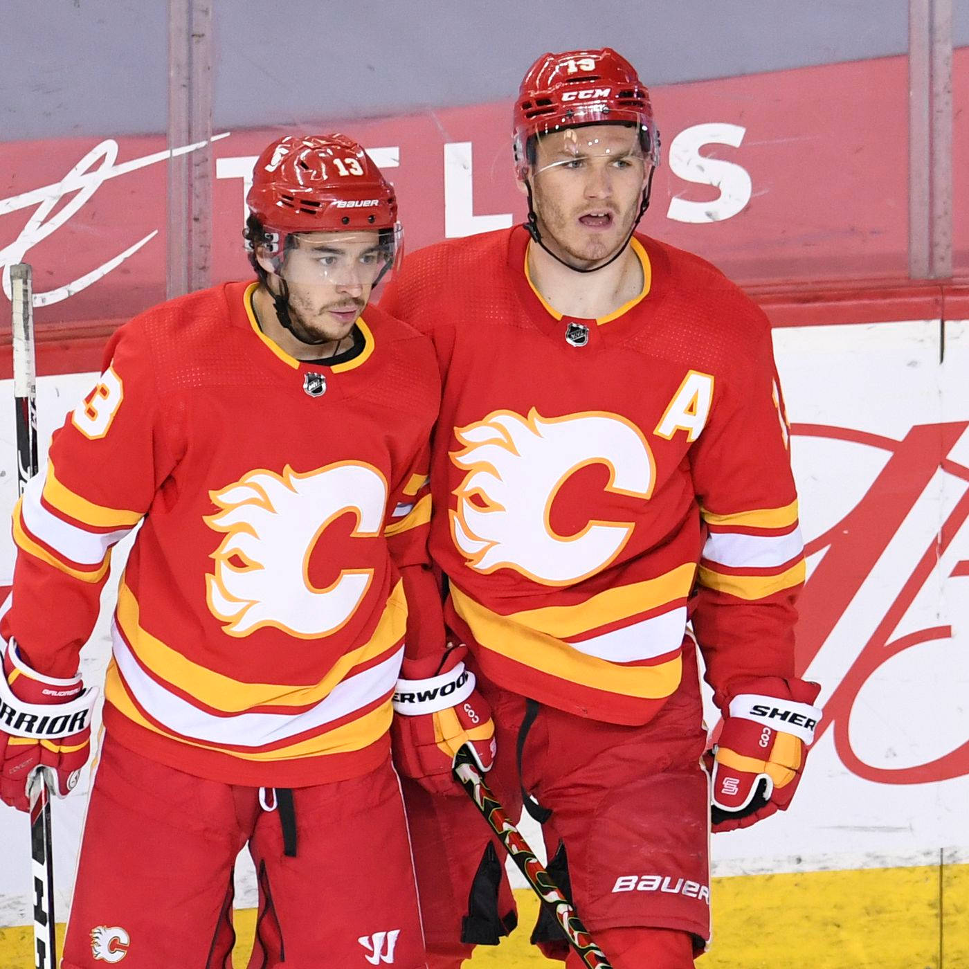 Johnny Gaudreau 桌布 壁紙 — 兩名穿著紅色球衣的卡加利火焰隊冰球球員在比賽期間站在冰場上手持球棍。