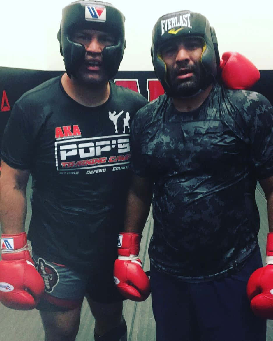 UFC 桌布 壁紙 — 兩名穿著訓練裝備的拳擊手在健身房中戴著紅色手套和頭盔，擺出激烈的姿勢。
