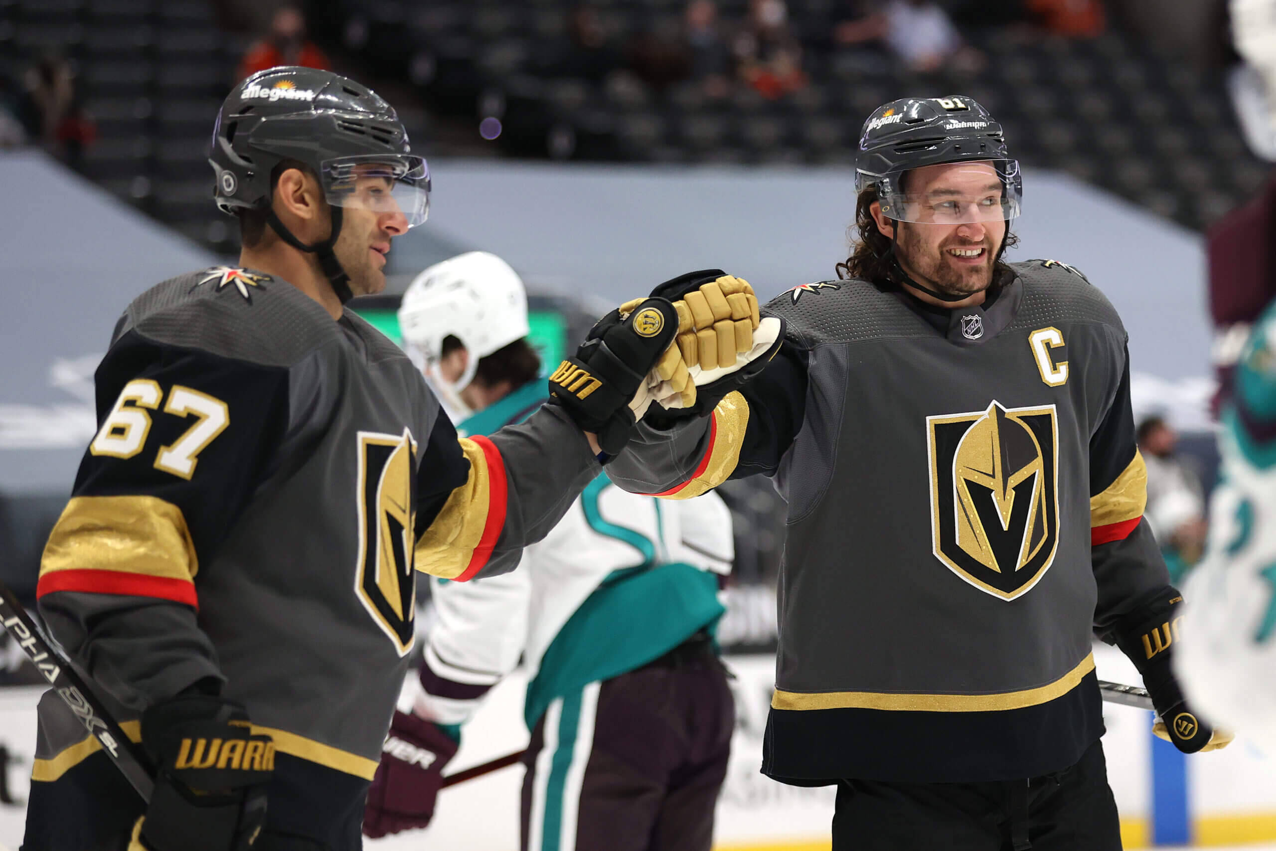 hockey 桌布 壁紙 — 兩名穿著黑色和金色球衣的維加斯黃金騎士冰球球員在比賽中於冰上擊掌。