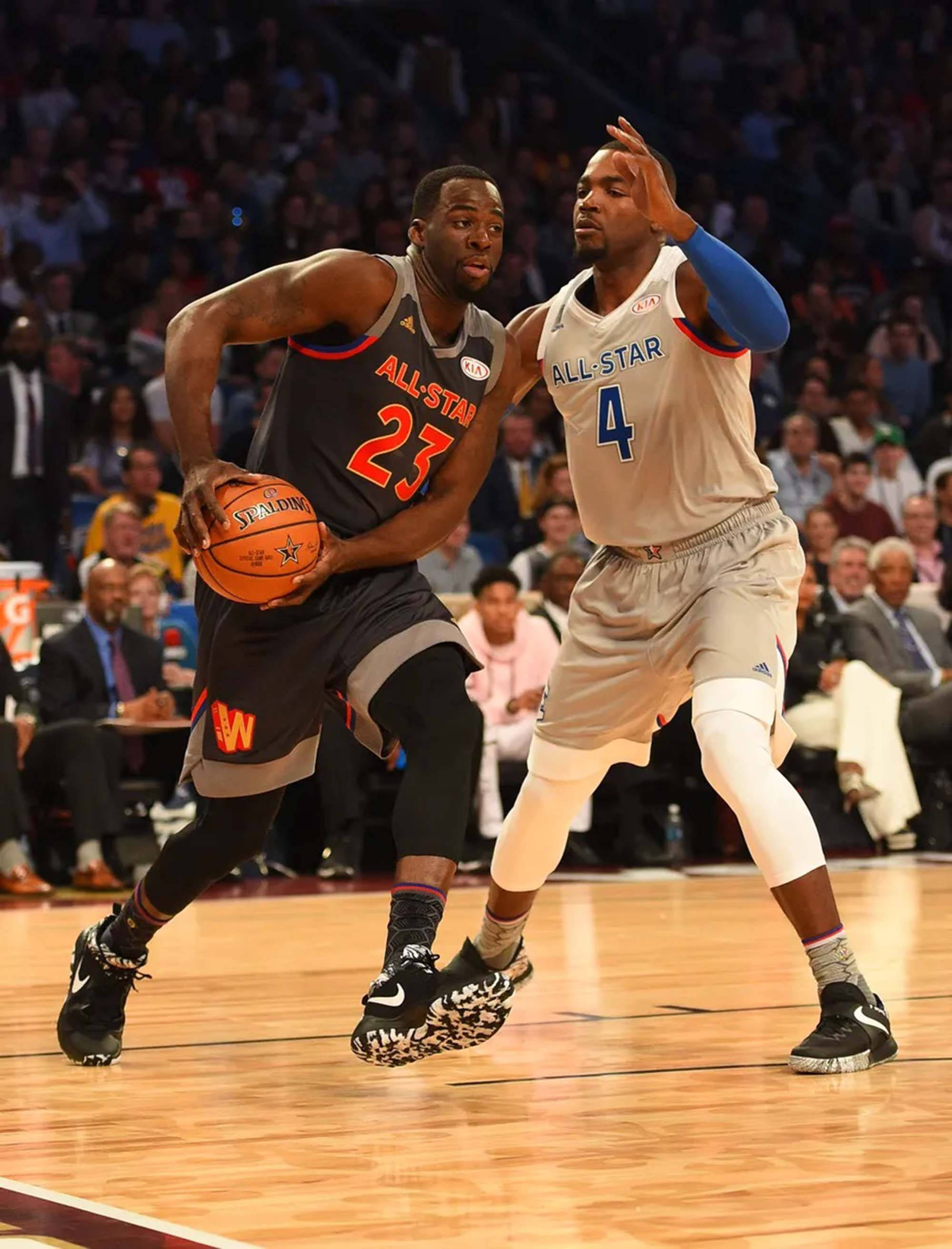 paul millsap 桌布 壁紙 — 兩名籃球運動員在全明星賽中激烈競爭，一人運球，另一人在擠滿觀眾的場館中防守。