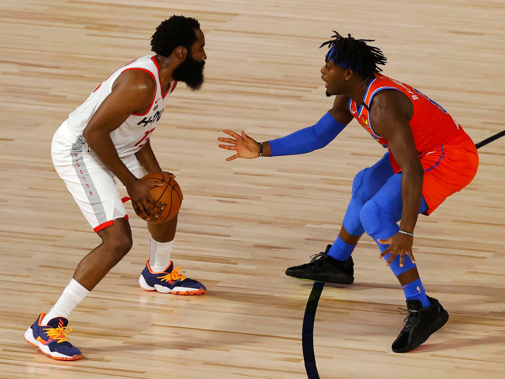 NBA 桌布 壁紙 — 兩名籃球運動員在拋光木地板上激烈競爭，一人運球，另一人積極防守。