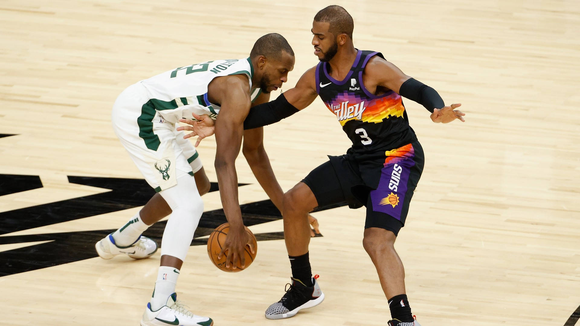 Khris Middleton 桌布 壁紙 — 兩名籃球運動員在拋光木地板的職業比賽中激烈爭奪運球。