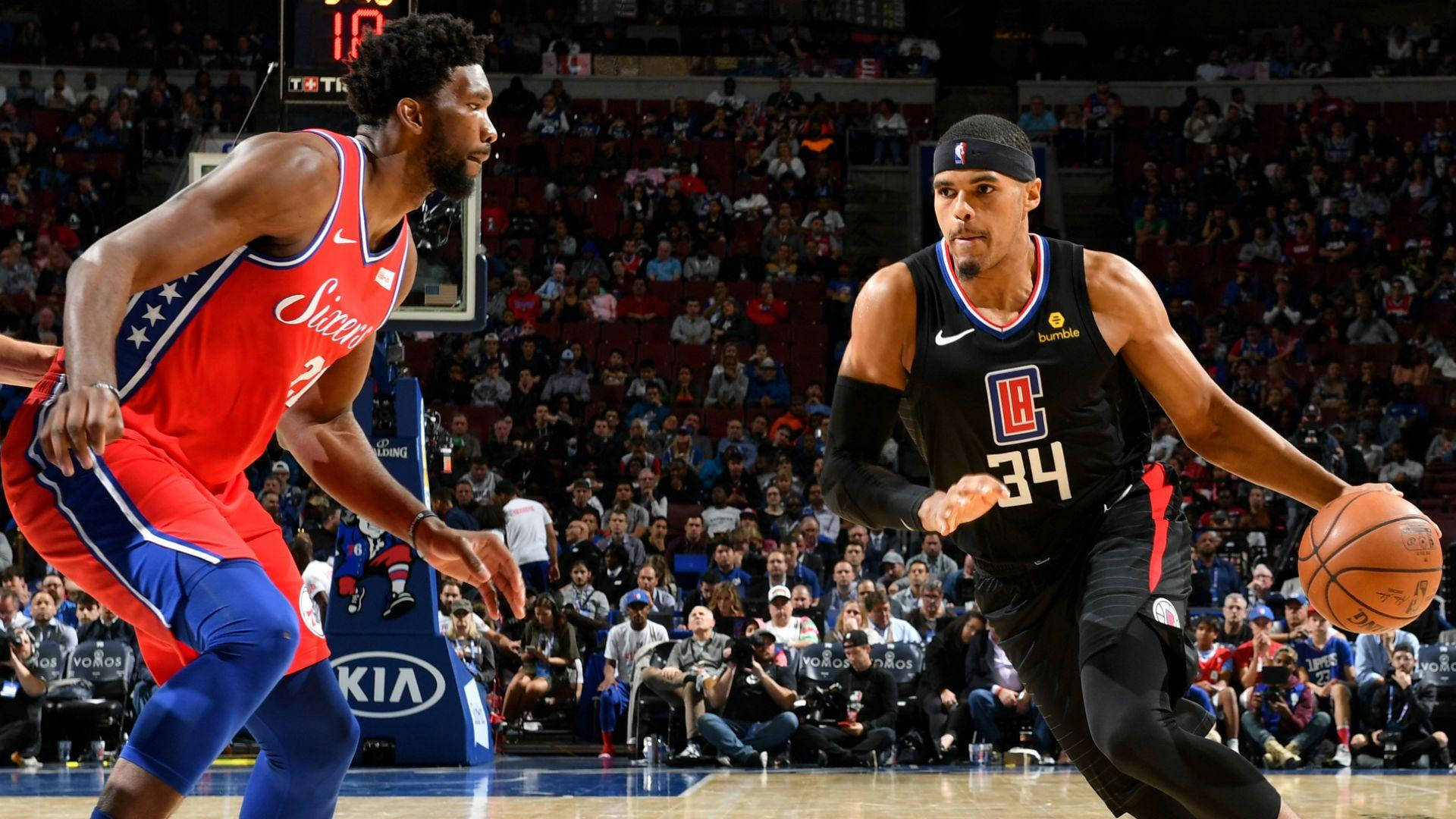 NBA 桌布 壁紙 — 兩名籃球運動員在擠滿觀眾的場館中激烈競爭，一人運球，另一人防守。