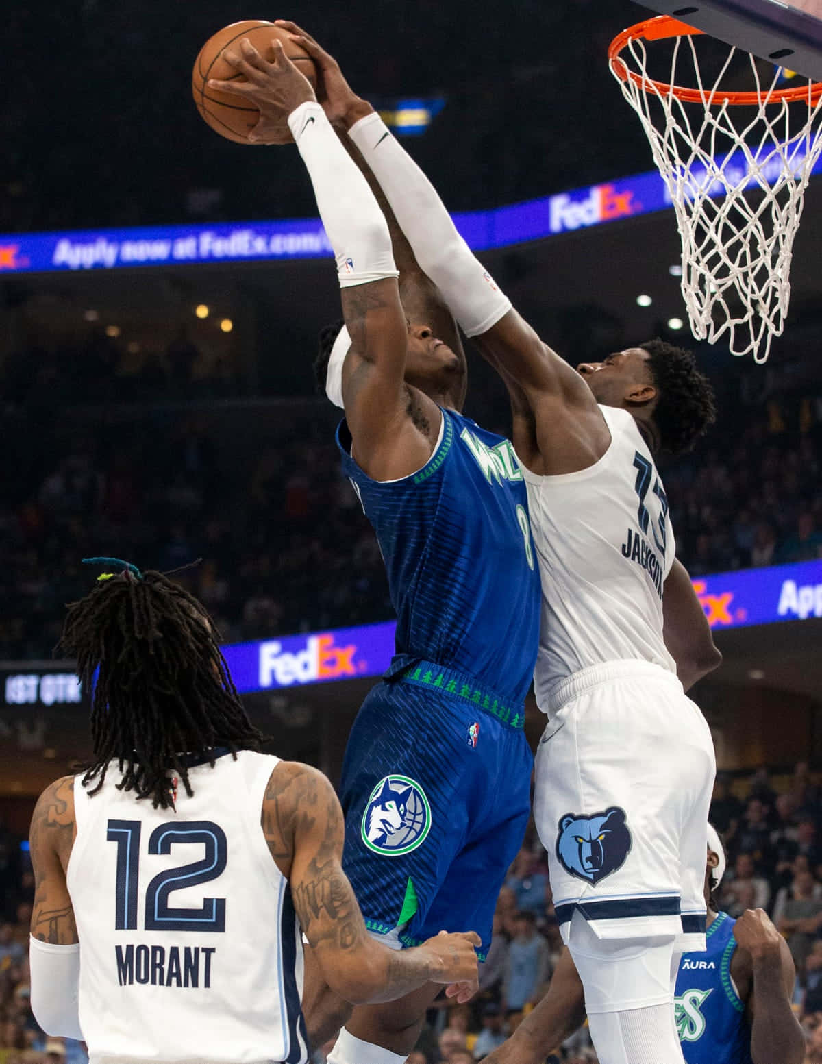 Minnesota Timberwolves 桌布 壁紙 — 兩名籃球運動員在擠滿觀眾的場館比賽中，為了灌籃而躍向籃框，展開激烈的空中爭奪。