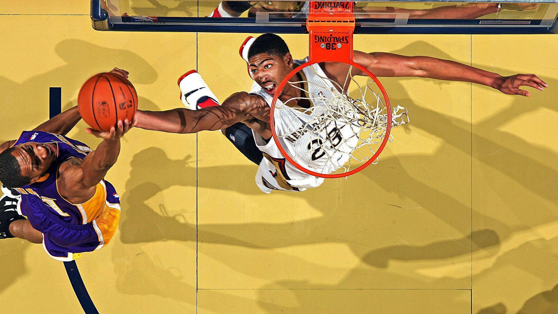 Anthony Davis 桌布 壁紙 — 兩名籃球運動員在明亮的場館燈光下，跳向籃框，在空中激烈爭奪球權。