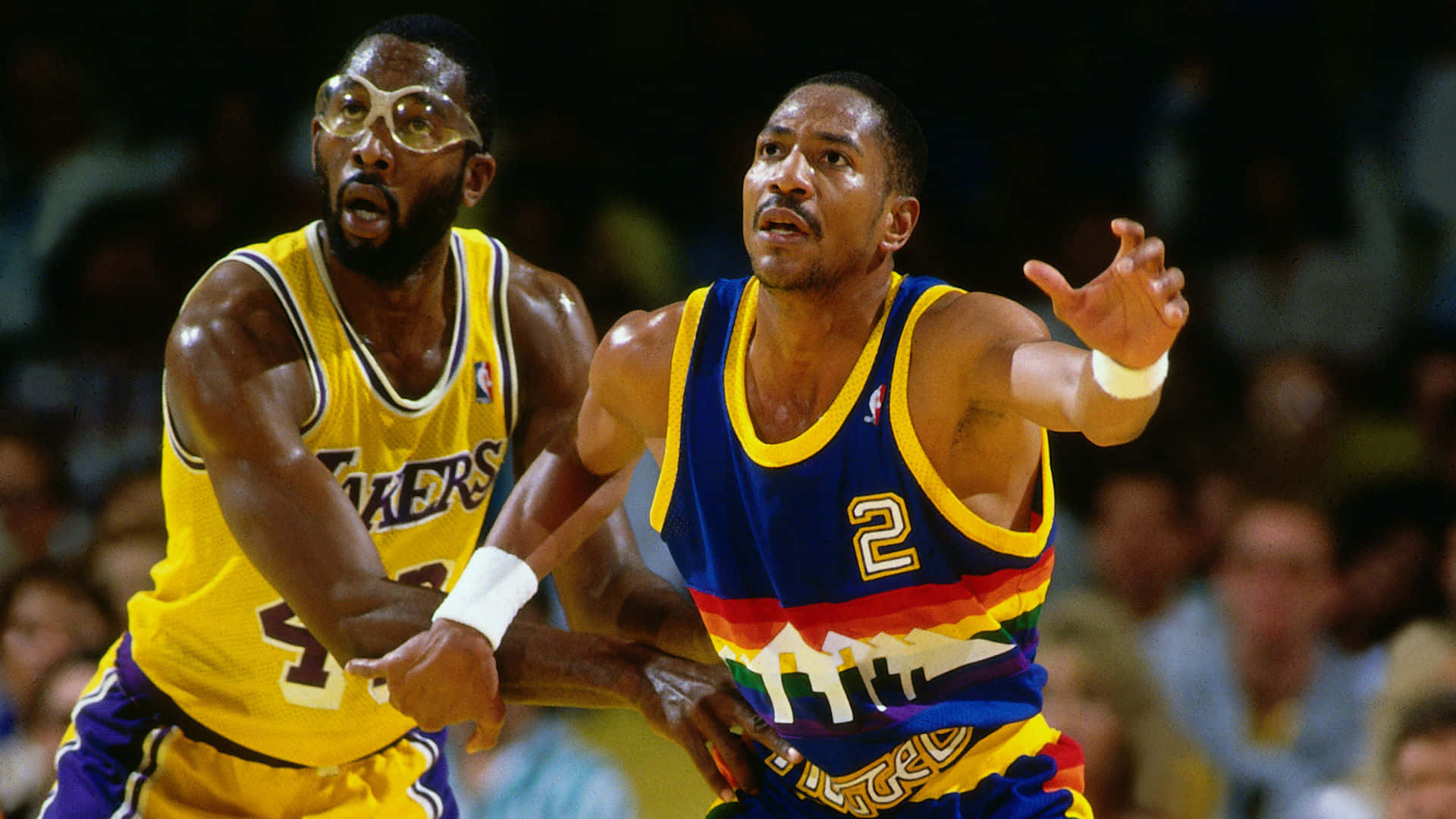 兩名NBA籃球運動員在比賽中行動，一人身穿湖人隊球衣，另一人身穿丹佛金塊隊球衣。 — NBA 壁紙