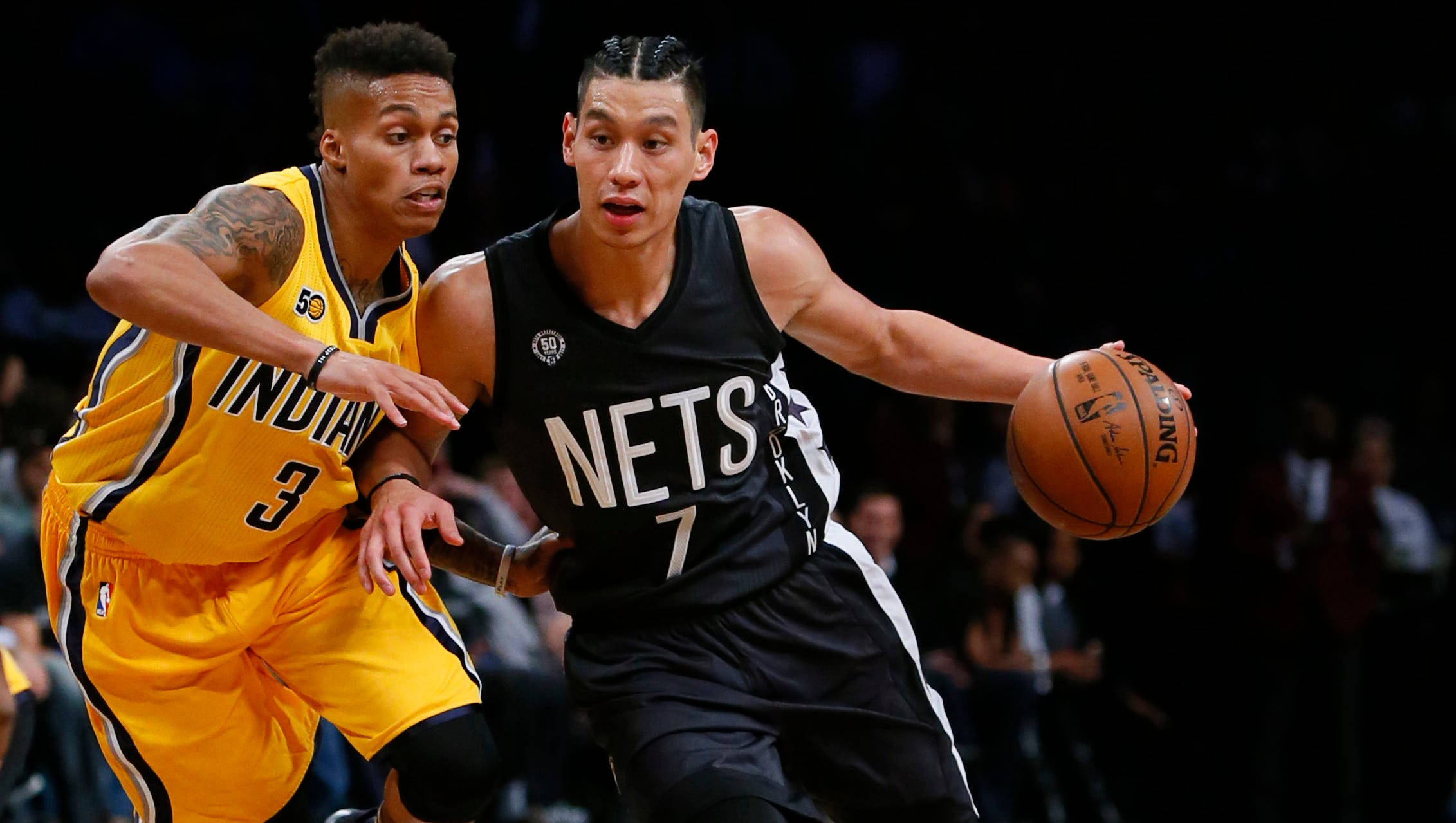 Lin 桌布 壁紙 — 兩名籃球運動員在比賽中激烈競爭，一名身穿黃色球衣防守另一名身穿黑色球衣運球。